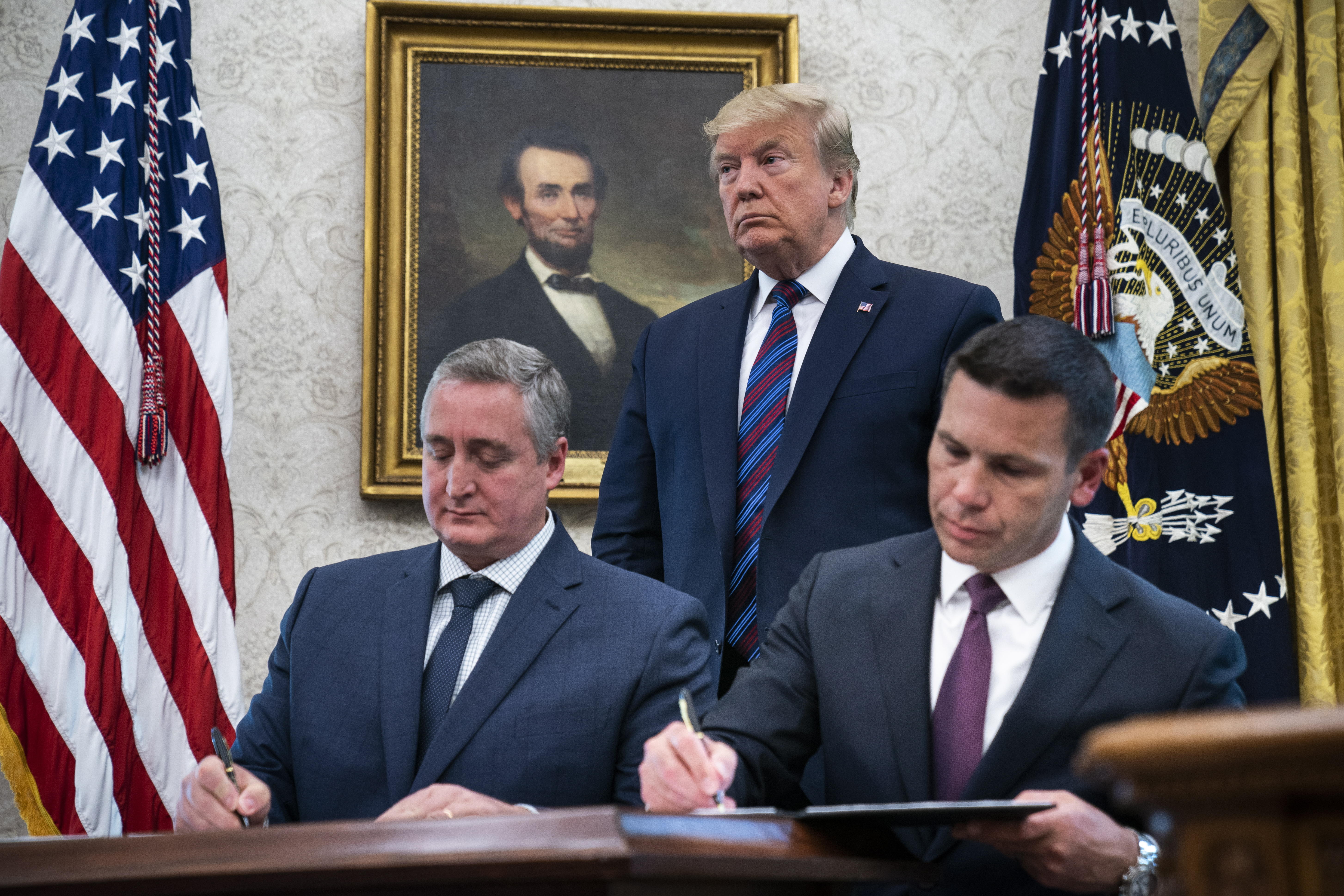 Enrique Degenhart y Kevin McAleenan firman el acuerdo, ante la mirada de Donald Trump. (Foto Prensa Libre: EFE)