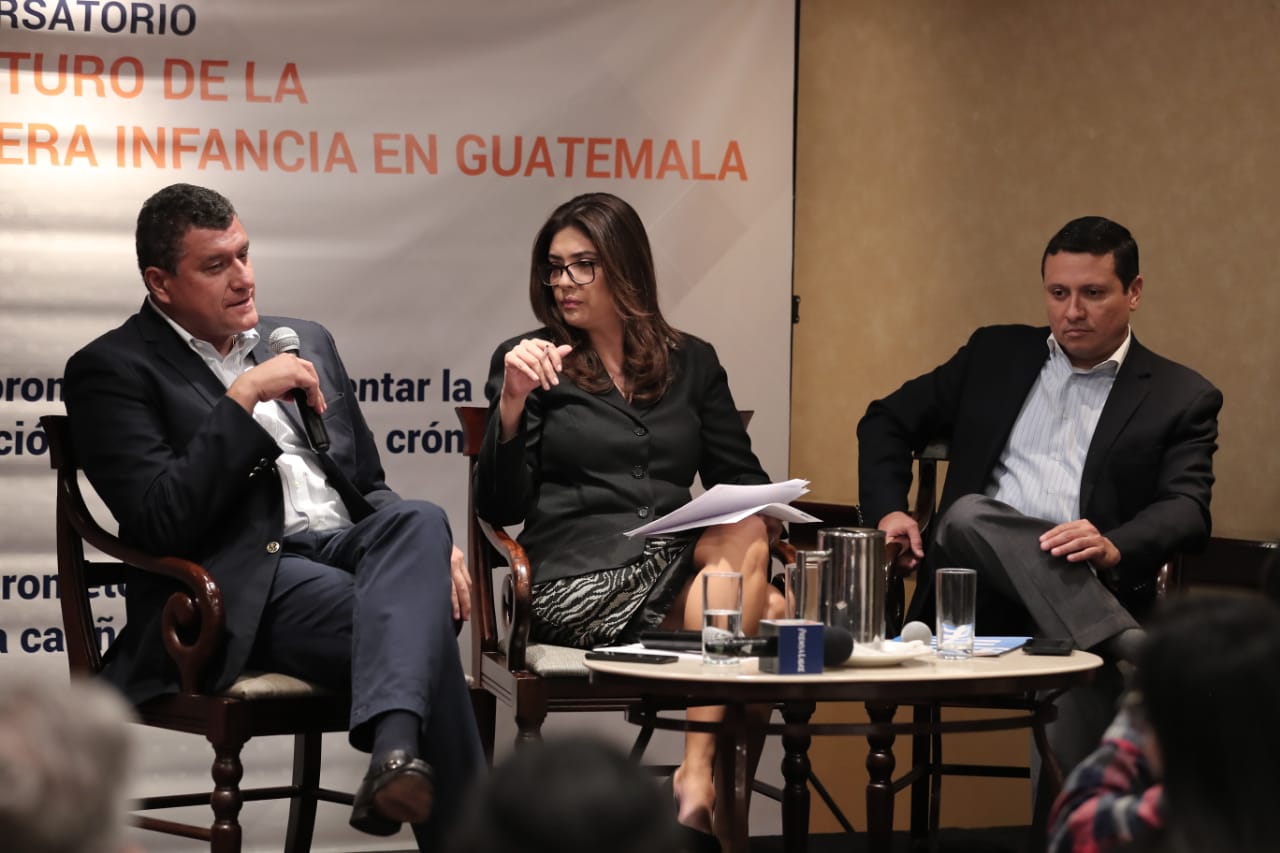 Guillermo Castillo, candidato de Vamos y Carlos Raúl Morales, de la UNE, conversan con la periodista María Luisa Gómez en el conversatorio sobre primera infancia. (Foto Prensa Libre:  Juan Diego González)