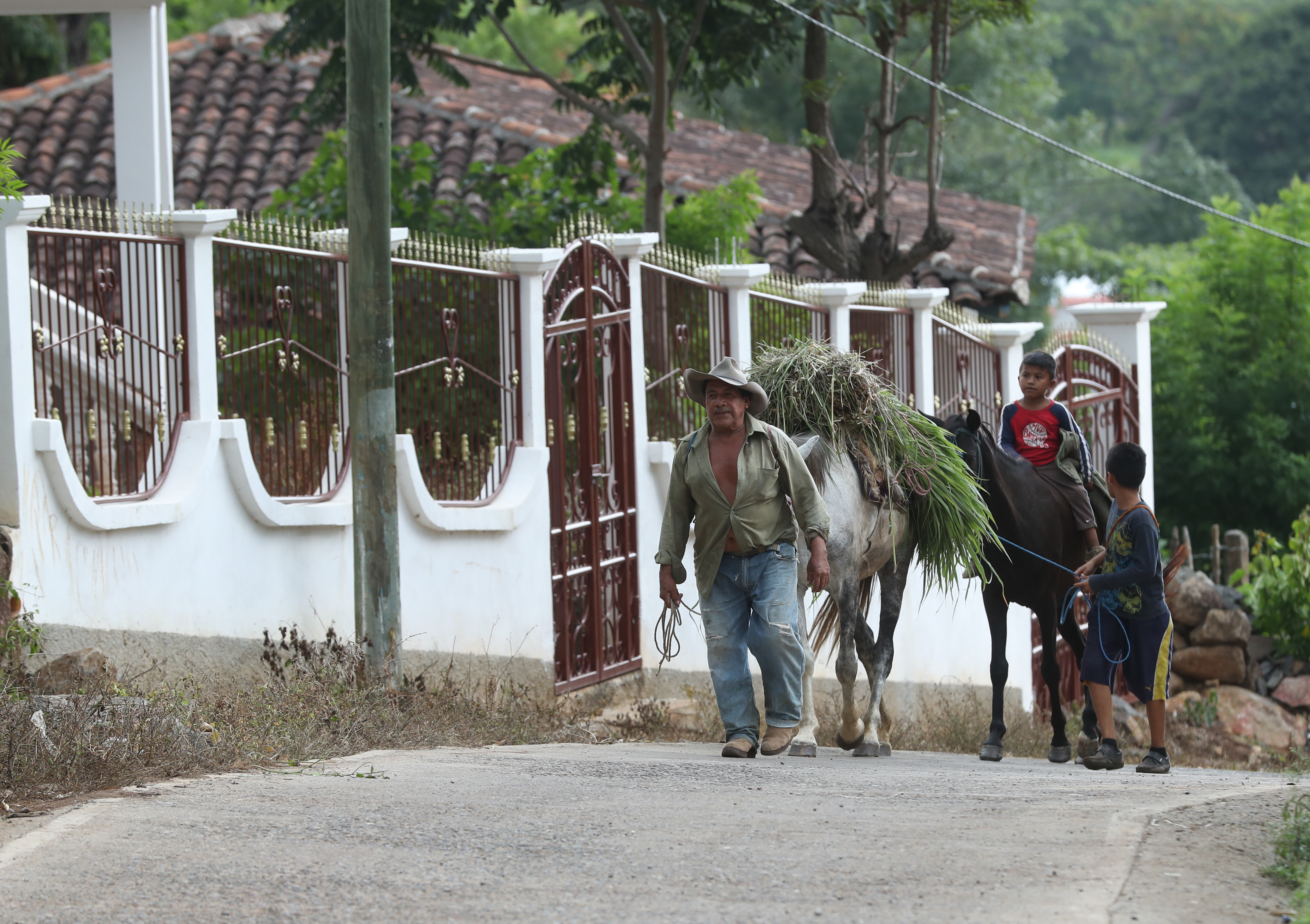 Un hombre camina por una calle de la aldea El Quebracho, frente a un vivienda inhabitada, como muchas en la comunidad de las cuales las familias se fueron a EE. UU. (Foto Prensa Libre: Esbin García)