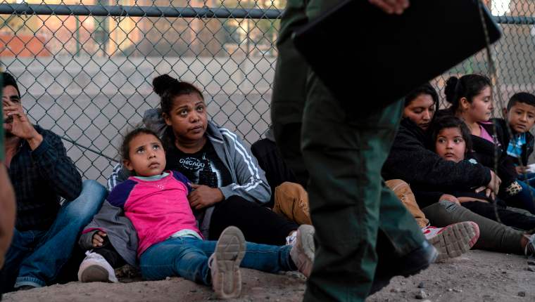 Migrantes centroamericanos esperan un vehículo en El Paso, Texas, que los lleve a un albergue y su posterior deportación. (Foto Prensa Libre: AFP)