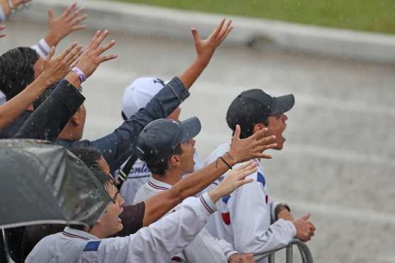 Un grupo de alumnos grita a la banda para animarla bajo los aguaceros. Foto Prensa Libre: Óscar Rivas