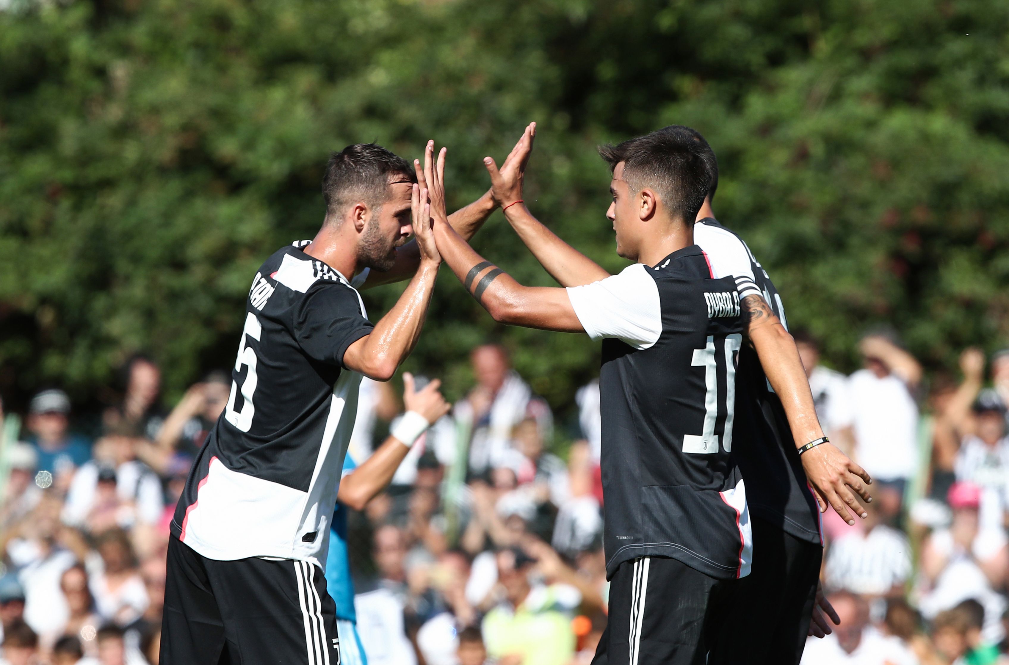 Paulo Dybala celebra con el mediocampista  Miralem Pjanic después de anotar en el partido amistoso de la Juventus a contra la Juventus B en Villar Perosa. (Foto Prensa Libre: AFP).