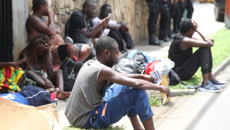 Inmigrantes descansan en la vía pública frente al albergue de Migración, en zona 5 de la ciudad de Guatemala, custodiados de policías. (Foto Prensa Libre: Hemeroteca PL)