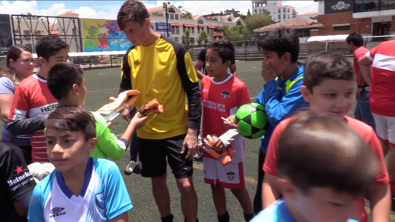 Nicholas Hagen le entrega sus guantes al pequeño Javier Gómez. (Foto Prensa Libre: Luis López)