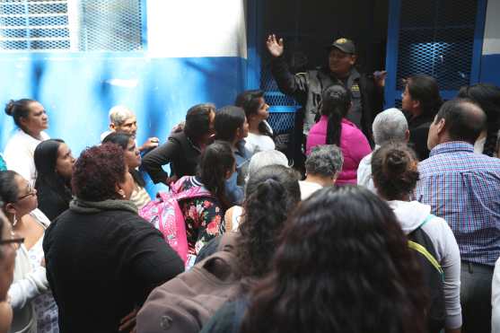 Un guardia asoma para avisar a las personas que deben esperar aún más tiempo debido a que ellos piden que el Director del Sistema Penitenciario les notifique por escrito los acuerdos alcanzados. Foto Prensa Libre: Óscar Rivas