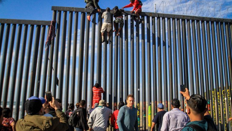 Decenas de migrantes intentan ingresar a Estados Unidos desde la zona de Playas Tijuana. (Foto Prensa Libre EFE)