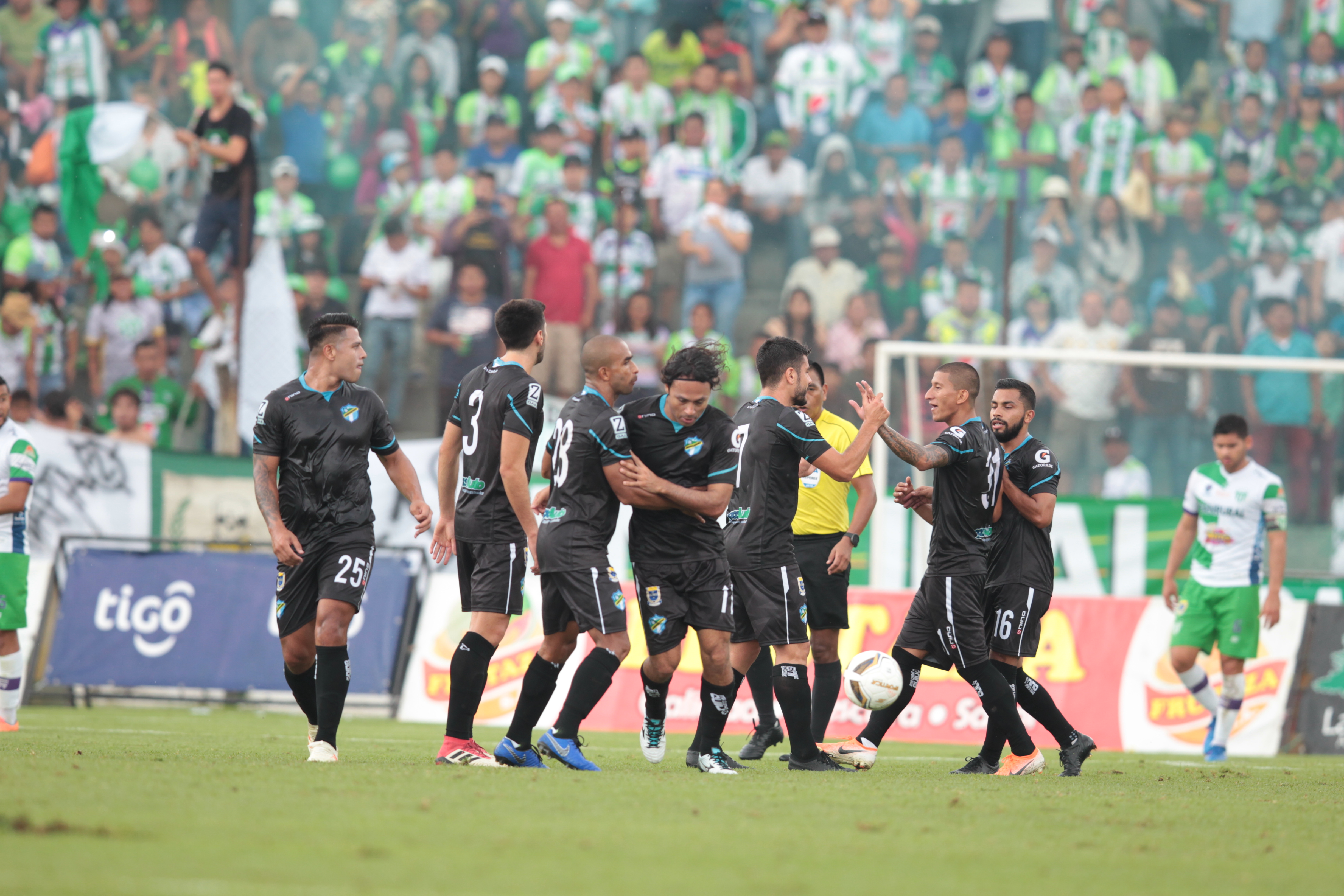 Los cremas festejan el triunfo contra Antigua. Atrás el árbitro Wálter López observa. (Foto Prensa Libre: Norvin Méndoza)