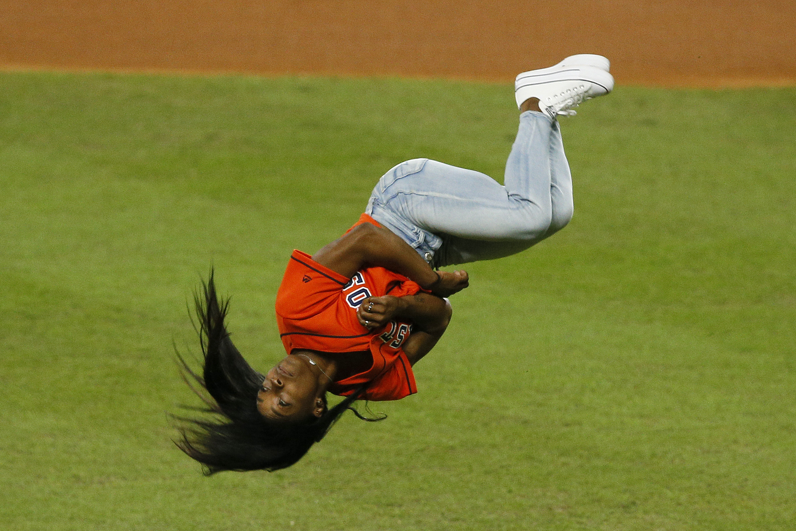 Simon Biles demostró un poco de su talento al hacer un salto mortal antes de hacer un saque de honor en la Serie Mundial. (Foto Prensa Libre: AFP) 