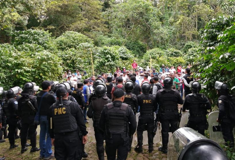 Agentes de la PNC dialogan con personas en una ocupación de tierras en Malacatán, San Marcos en 2019. (Foto Prensa Libre: HemerotecaPL). 