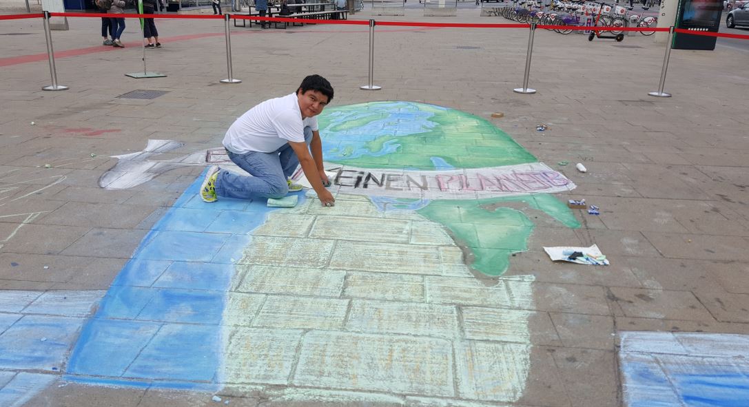 El pintor guatemalteco Gustavo Juárez García muestra una de las pinturas que elaboró en una de las principales plazas de Viena. (Foto Prensa Libre: Cortesía). 

