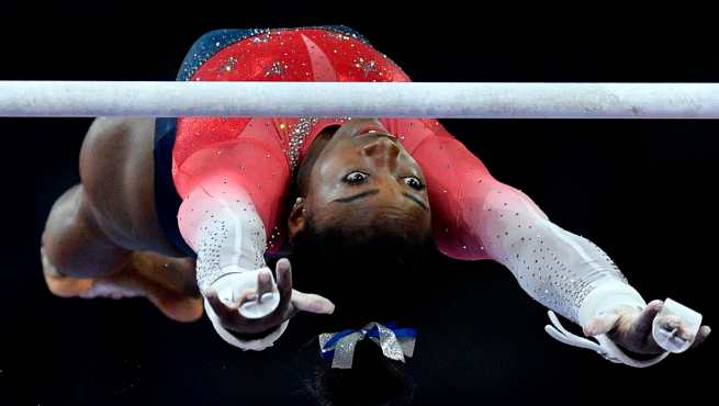 Simone Biles, de EE. UU., durante la final de equipos en las barras asimétricas. (Foto Prensa Libre: AFP)