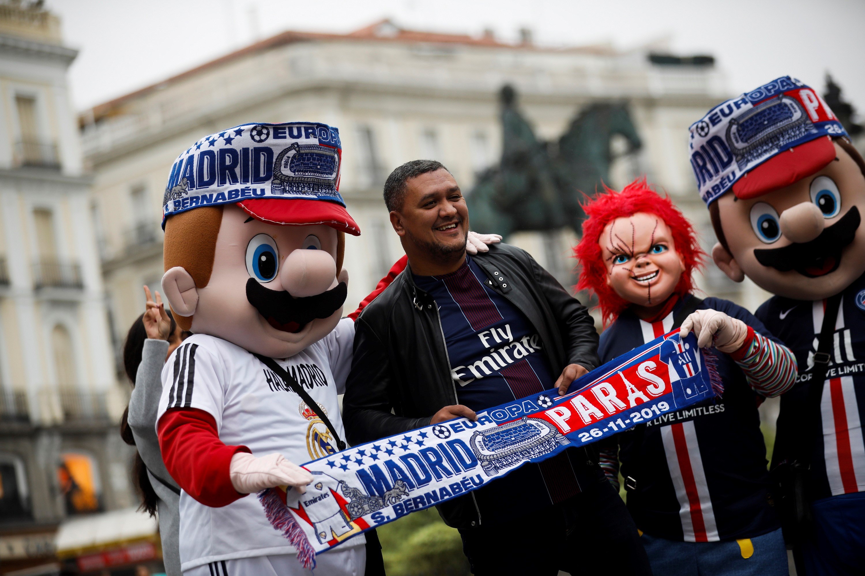 Los aficionados del PSG se hacen fotos con los trabajadores que se disfrazan en la Plaza Mayor de Madrid. (Foto Prena Libre EFE).