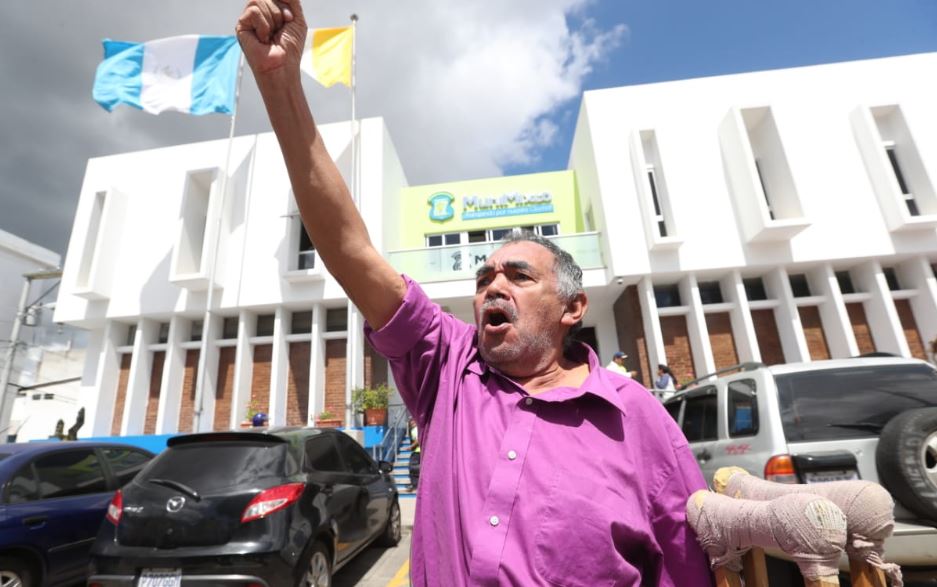 El exempleado Carlos Arturo Hernández, quien usa muletas por un accidente laboral, se manifiesta frente a la comuna de Mixco. (Foto Prensa Libre: Érick Ávila).