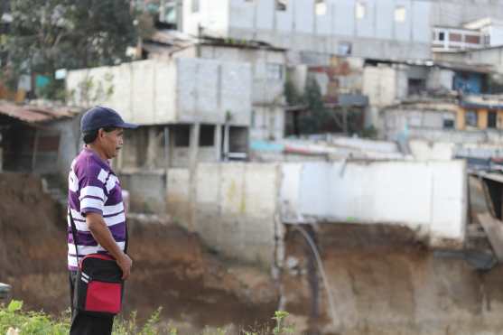 Santos Ixcoy se lamenta ante la perdida de su vivivenda la cual se ve al fondo. Foto Prensa Libre: Óscar Rivas