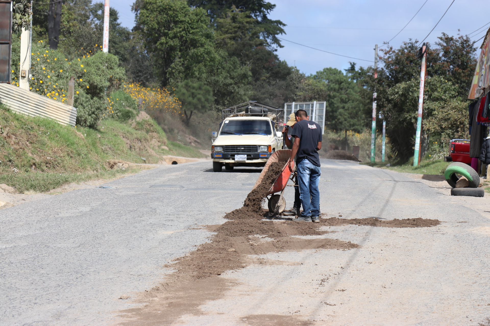 Transportistas rellenan los agujeros en la carretera a San Pedro Jocopilas, Quiché con arena,  (Foto Prensa Libre: Héctor Cordero).