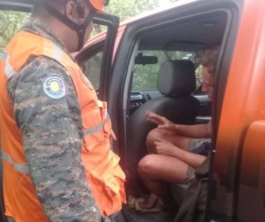 Rescatista observa al turista alemán localizado con vida. (Foto Prensa Libre: Conred).  