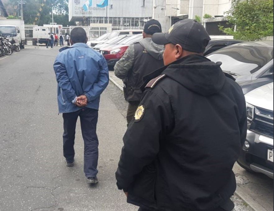 Policías conducen a uno de los detenidos por el caso de estafa a la Torre de Tribunales (Foto Prensa Libre: Cortesía PNC).