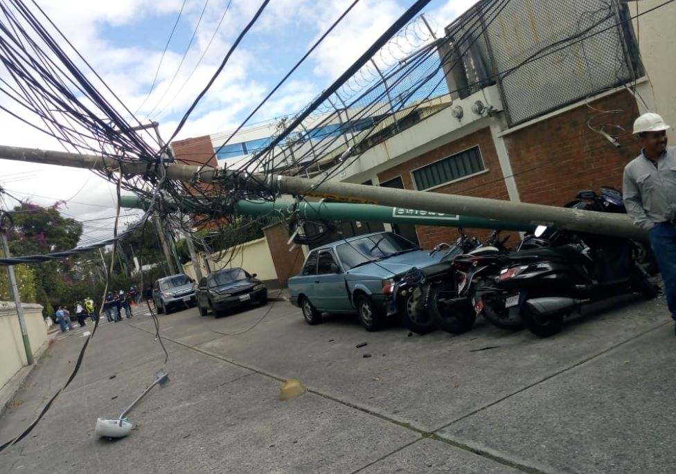 Caída de árbol provocó que dos postes fueran derribados en la zona 10 de la capital. (Foto Prensa Libre: Conred). 