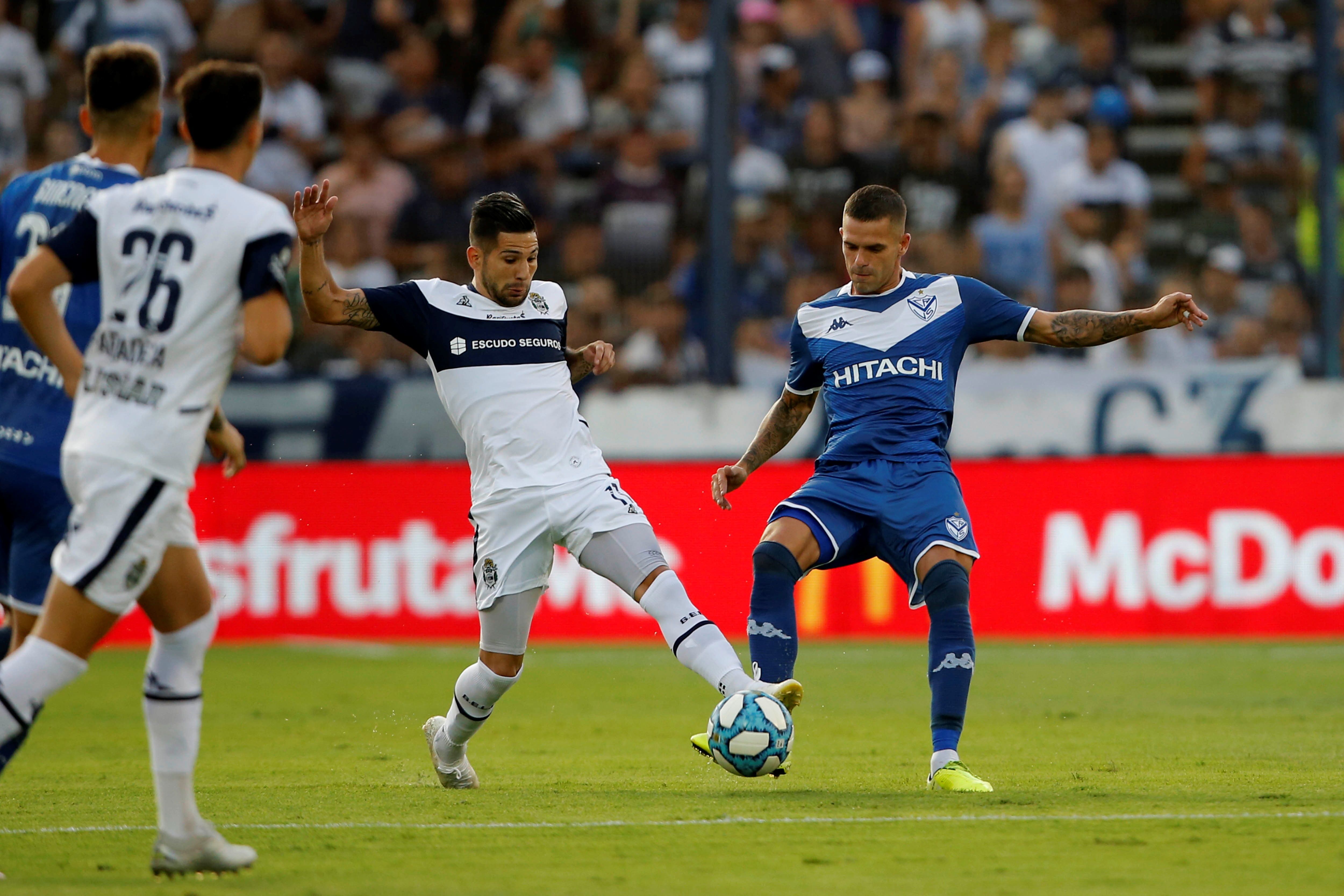 Jhonatan Agudelo (i), de Gimnasia y Esgrima, disputa el balón con Fernando Gago (d), de Vélez Sarfield. (Foto Prensa Libre: EFE)