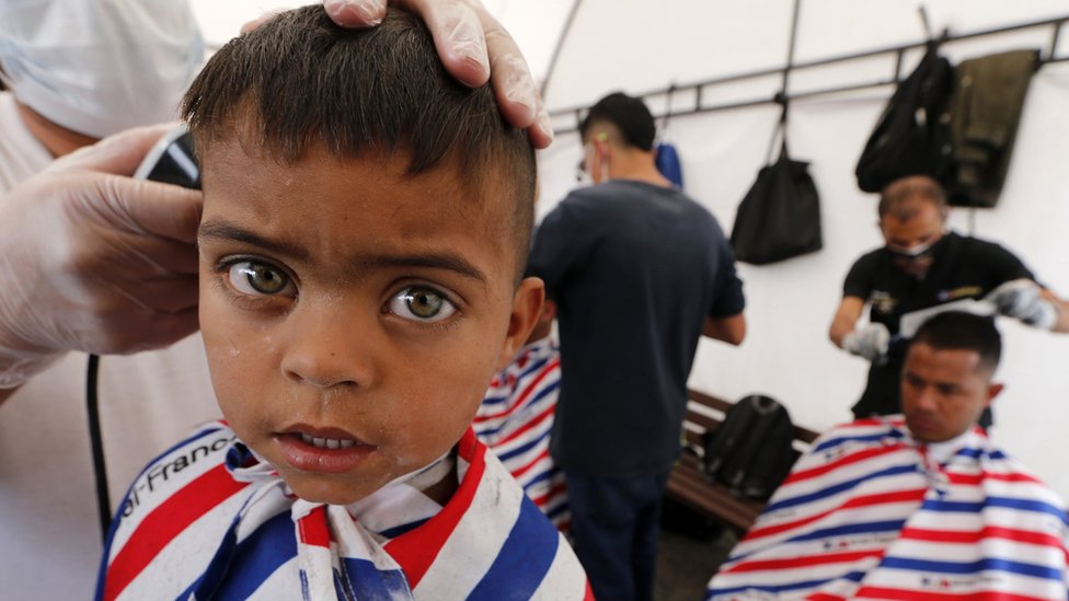 Miles de familias venezolanas han llegado a Colombia en los últimos años. En esta imagen, inmigrantes venezolanos se cortan el pelo a su llegada a la estación de autobuses de Bogotá.