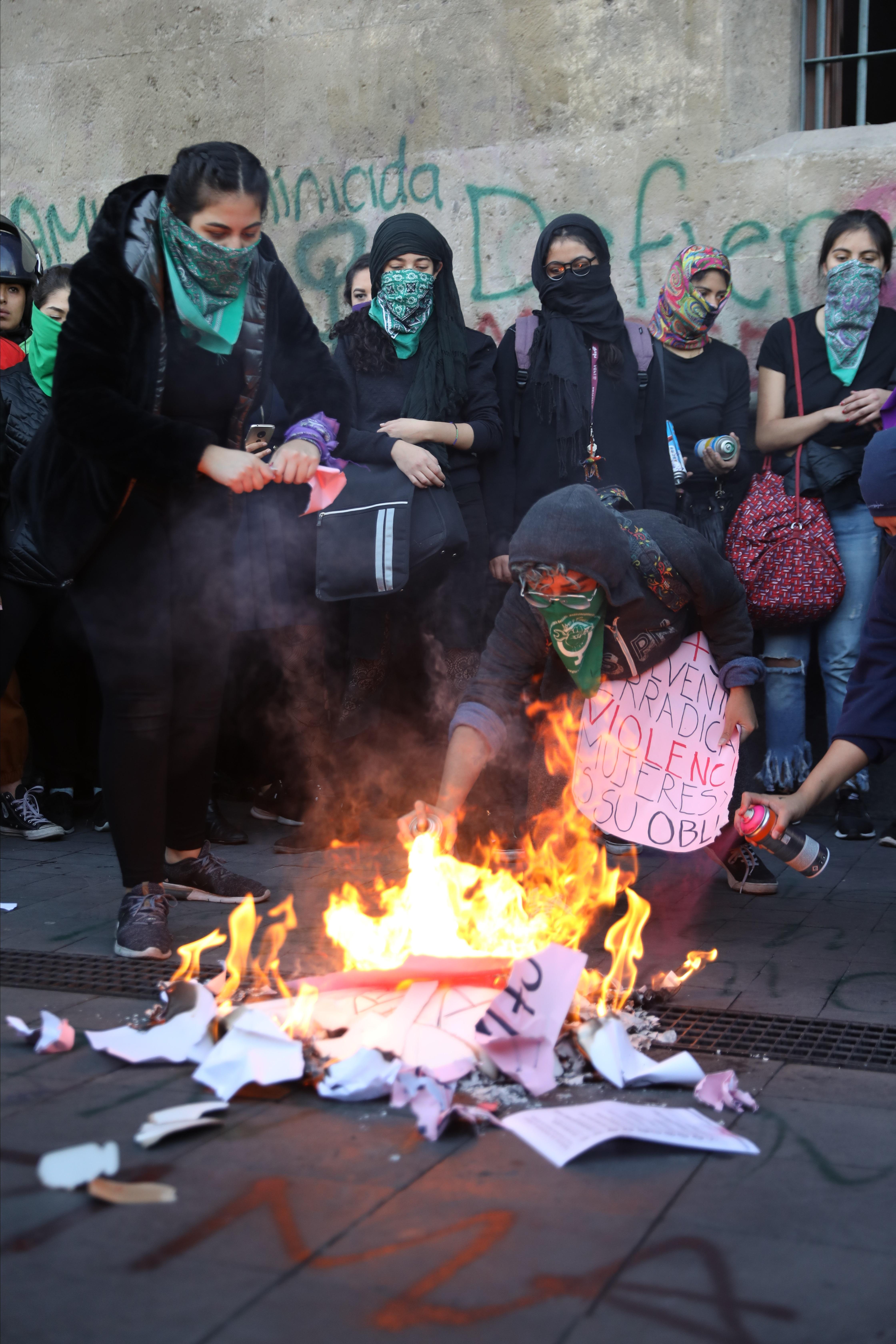 Colectivos y organizaciones feministas prenden una fogata en forma de protesta frente al Palacio Nacional por la muerte de Fátima, la niña de siete años cuyo cuerpo fue localizado el pasado fin de semana, en Ciudad de México. (Foto Prensa Libre: EFE)