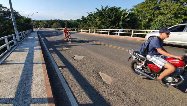 Motoristas esquivan boquetes sobre el puente de Río Dulce. (Foto Prensa Libre: Dony Stewart)