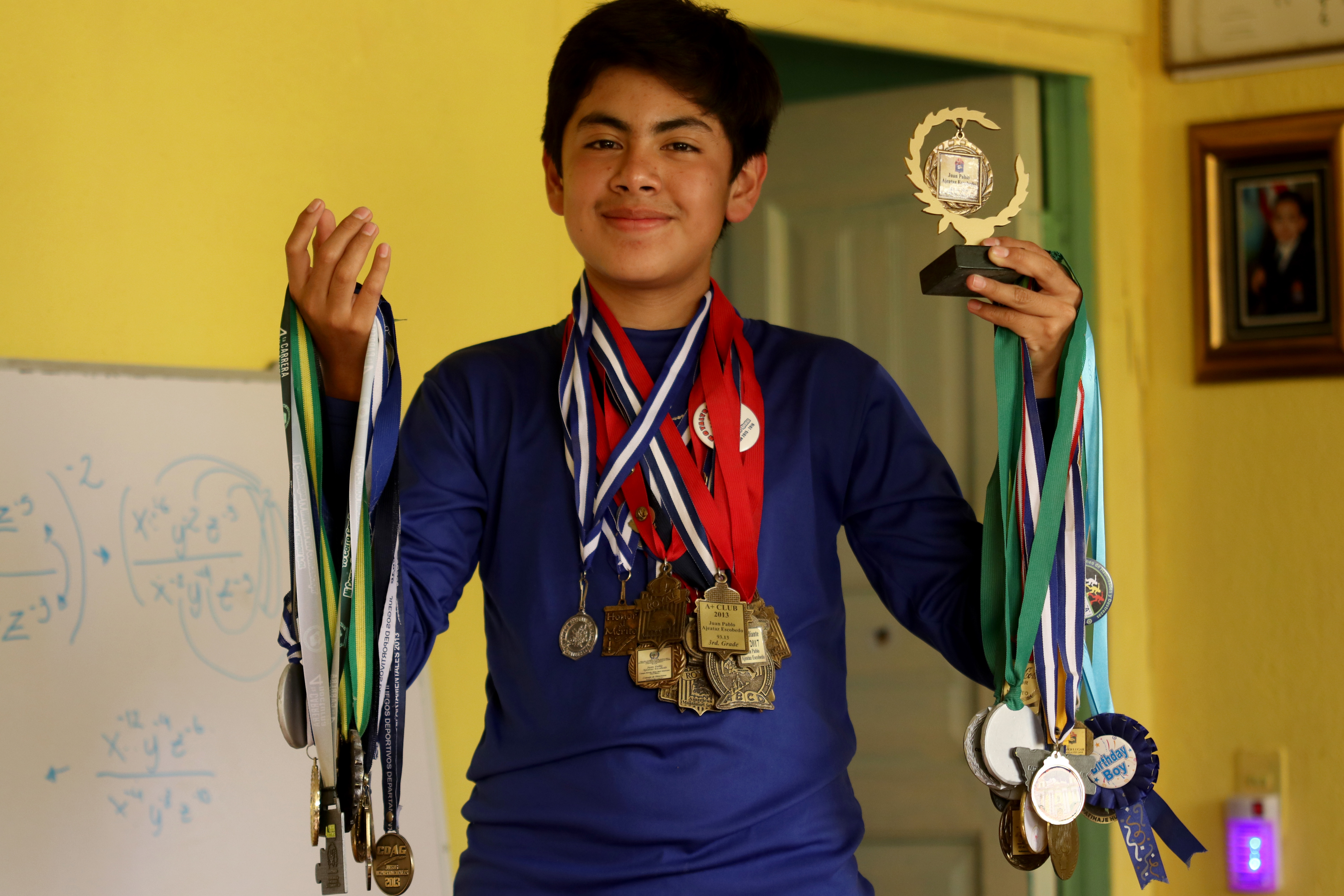 Juan Pablo Ajeataz Escobedo muestra parte de las medallas que ha obtenido en actividades académicas en distintas partes del país. (Foto Prensa Libre: Mike Castillo)