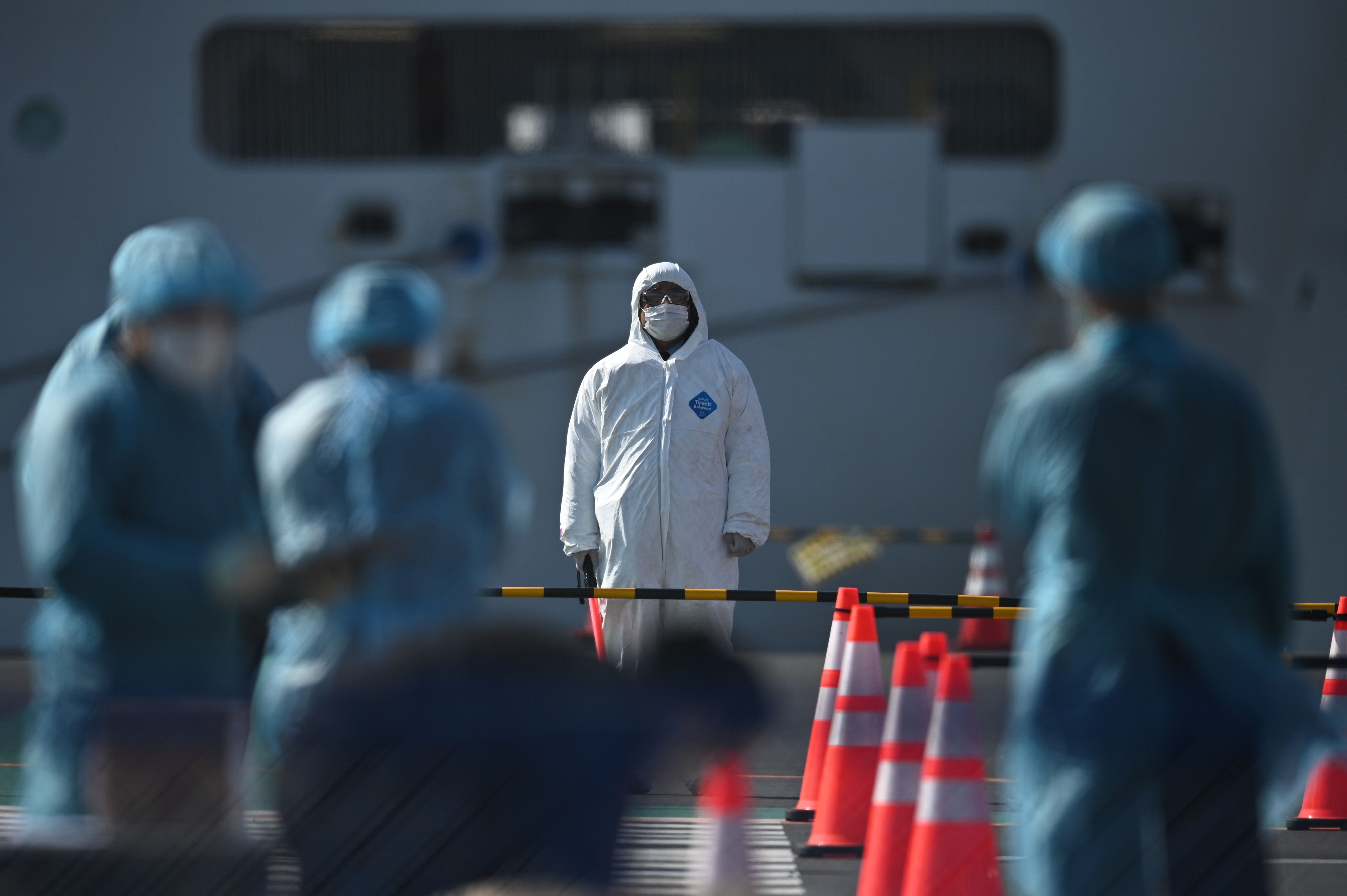 Personas expuestas a contagiados por el coronavirus se protegen con trajes y máscaras como medida de prevención. (Foto Prensa Libre: AFP)