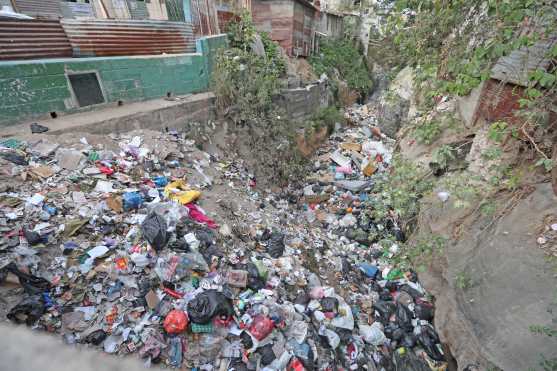 Del otro lado del puente se puede observar un basurero clandestino el cual no deja que el agua residual fluya en el desagüe. Foto Prensa Libre: Óscar Rivas