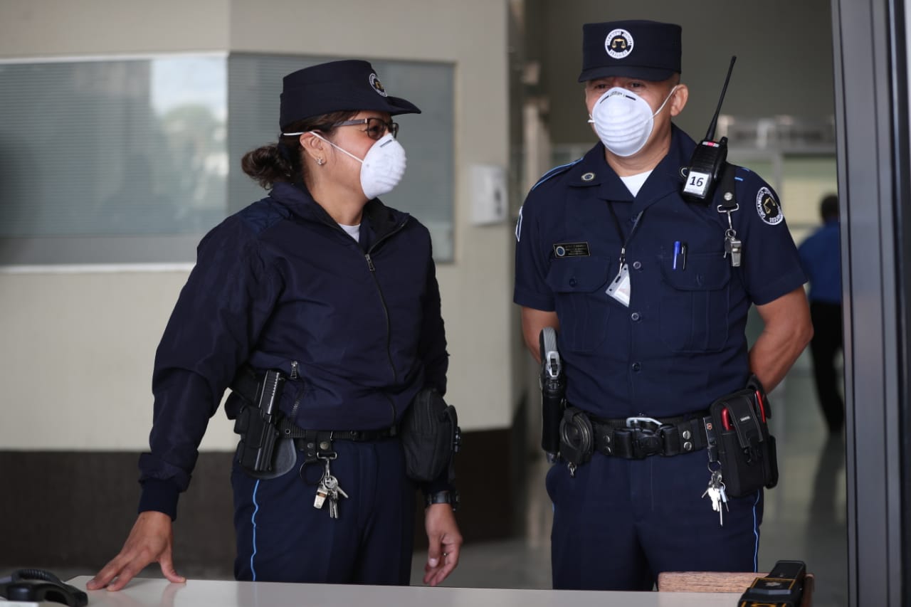 Dos agentes del Organismo Judicial revisan a los visitantes a Torre de Tribunales portando mascarillas. (Foto Prensa Libre: Carlos Hernández Ovalle)