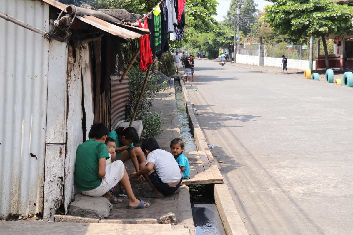 Niños juegan a la orilla del drenaje en el caserío Nuevo Cerritos que contiene las aguas servidas. (Foto Prensa Libre: Carlos Paredes)