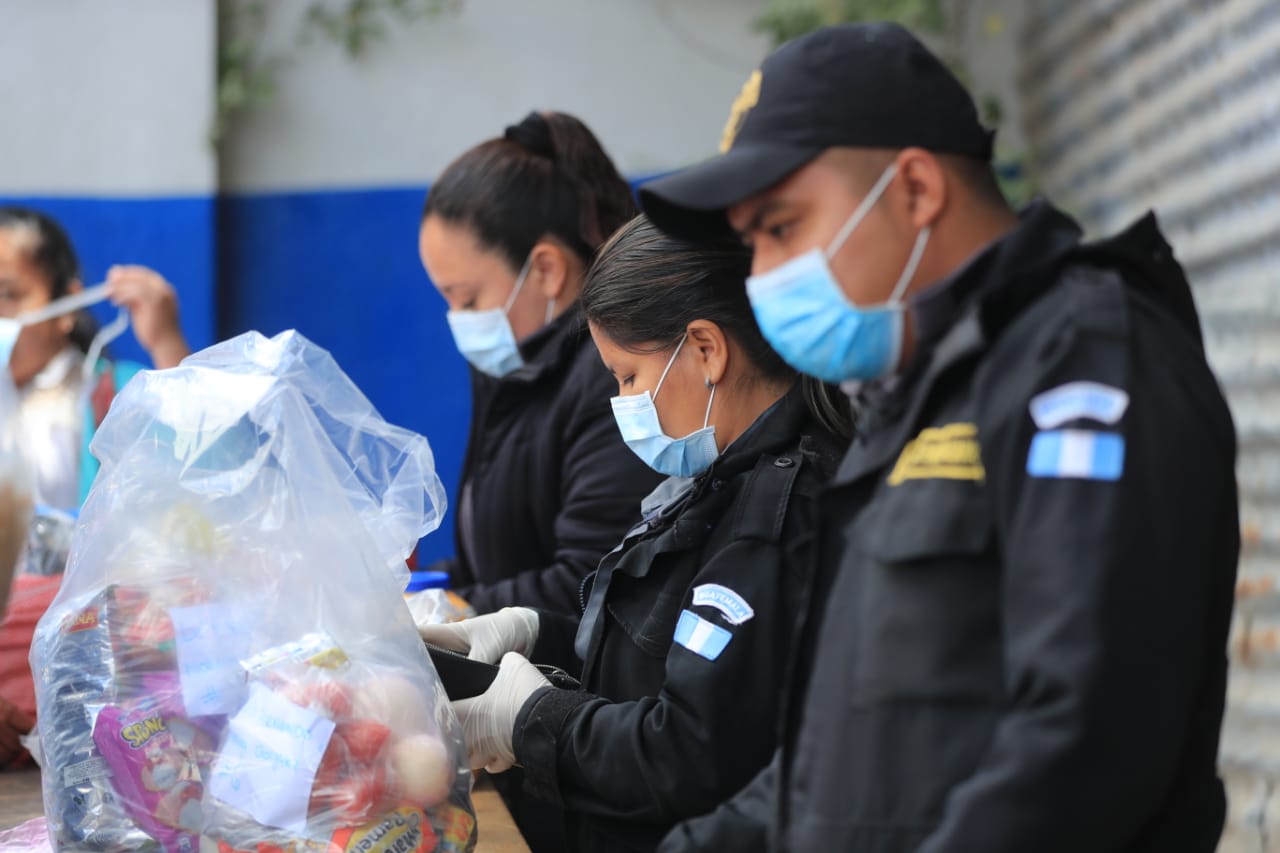 Custodios del Sistema Penitenciario revisan con guantes y mascarilla una bolsa con alimentos en el Centro Preventivo para Varones, en la zona 18.   (Foto Prensa Libre: Juan Diego González)  