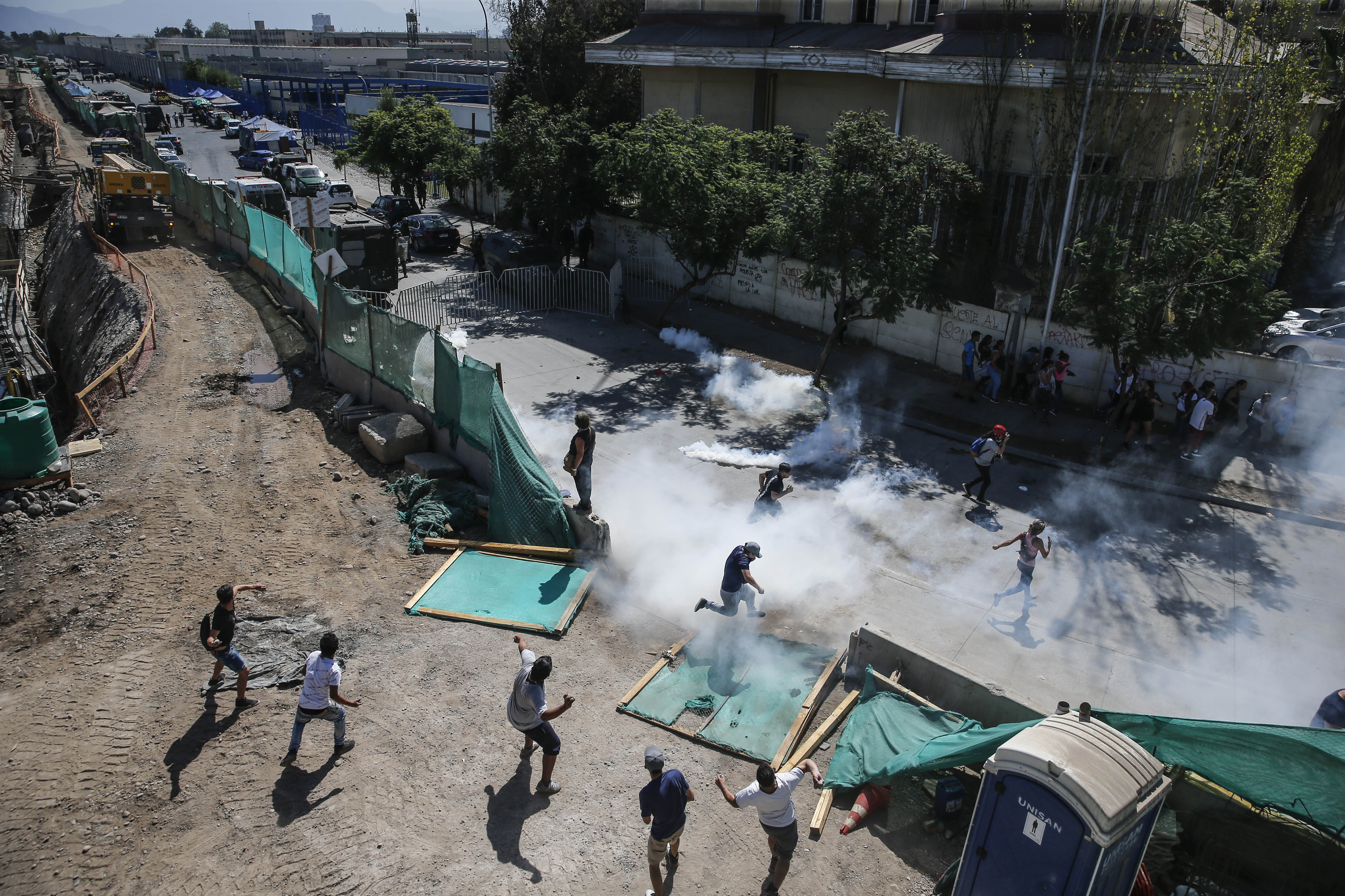 Los familiares de los reclusos de la cárcel "Santiago 1" chocan con las fuerzas de seguridad fuera de la prisión en Santiago de  Chile. (Foto Prensa Libre: AFP) 