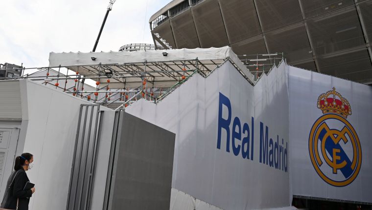 Una mujer con una máscara protectora llega al estadio Santiago Bernabeu en Madrid cuando los jugadores del Real Madrid entraron en cuarentena debido al brote de coronavirus, el 12 de marzo de 2020.(Photo by GABRIEL BOUYS / AFP)