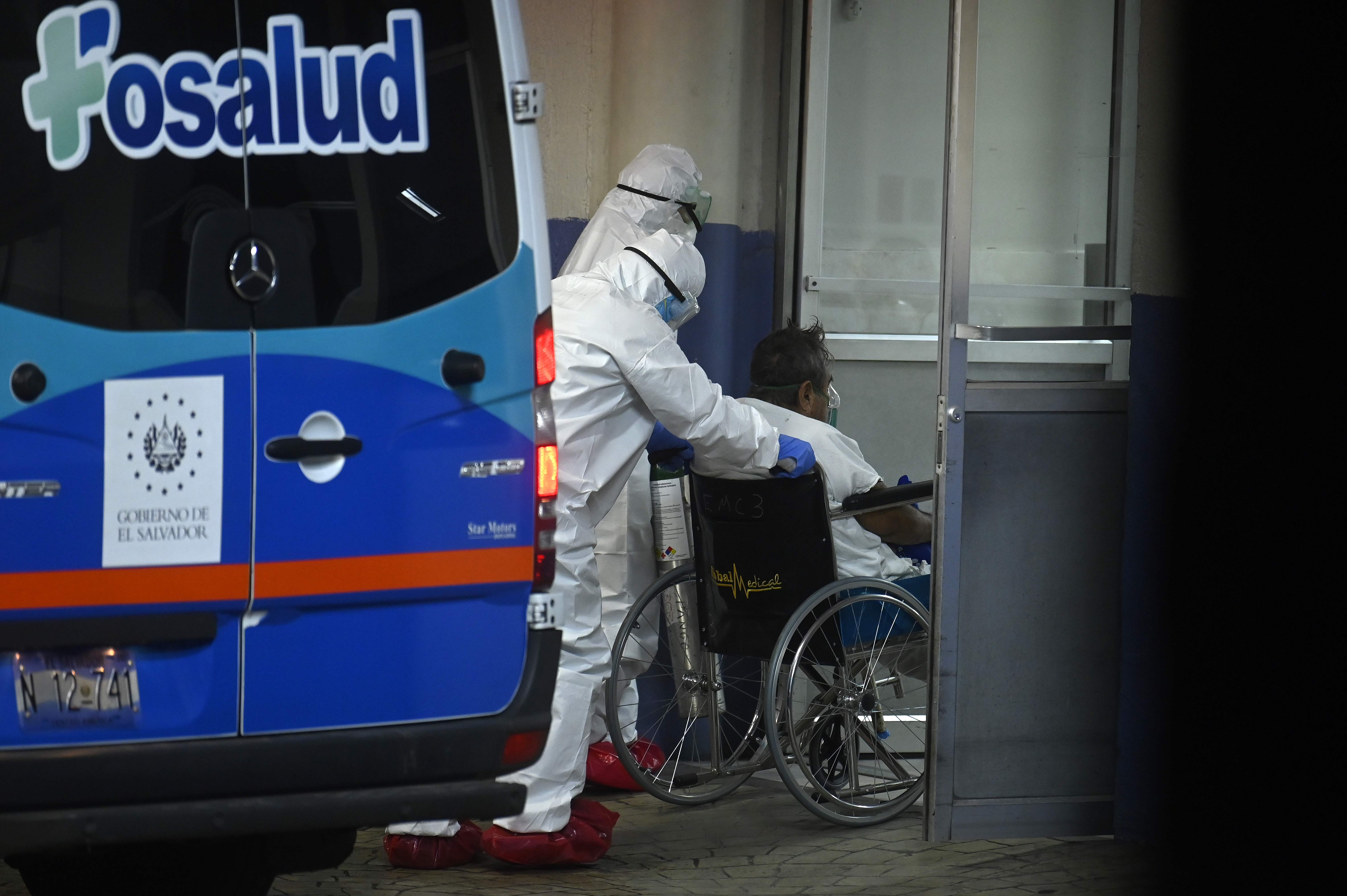 Personal medico lleva a un paciente infectado con el nuevo coronavirus en el hospital de Amatepec en San Salvador. (Foto Prensa Libre: AFP)