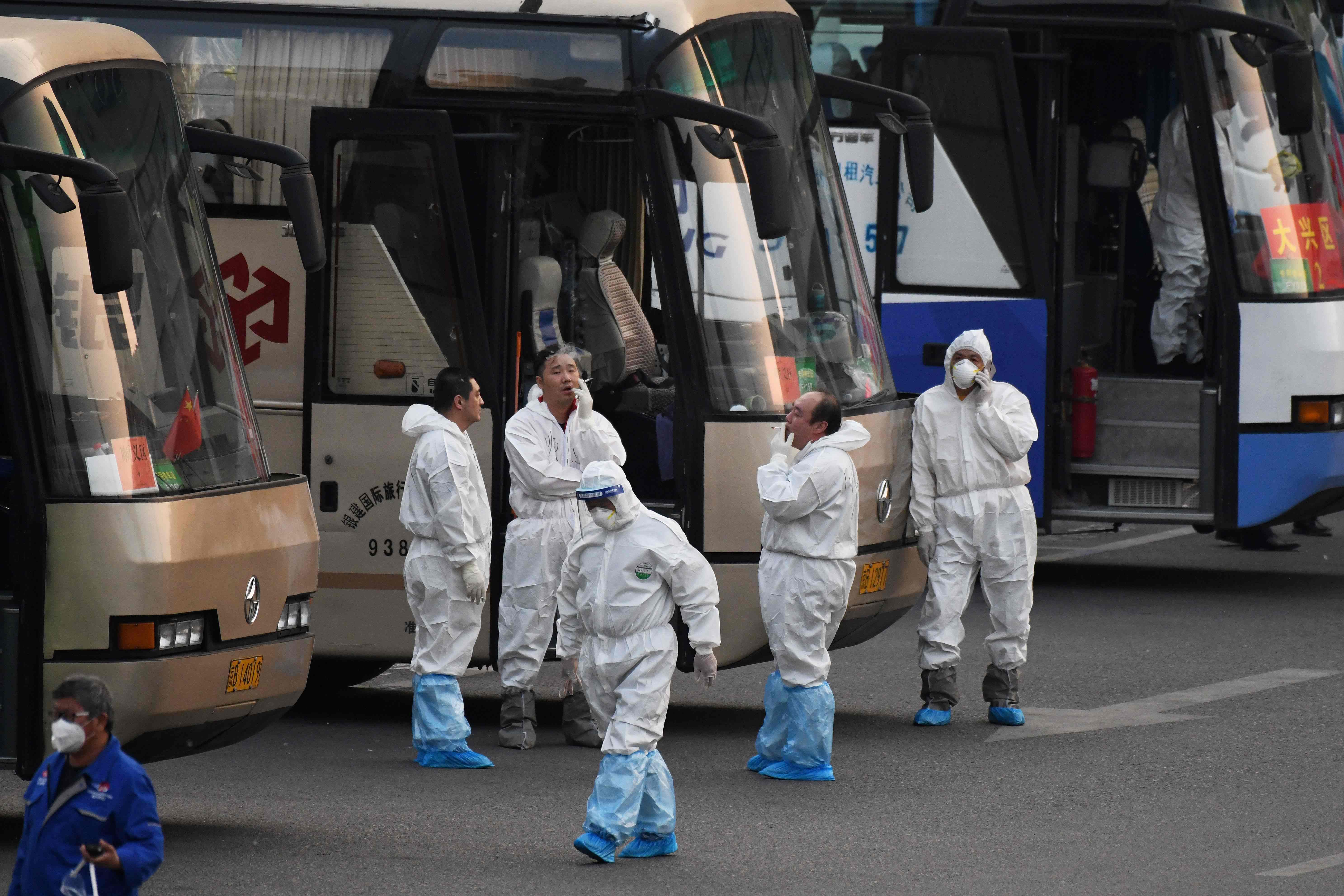 Trabajadores de una empresa en Wuhan, China, mantienen las medidas de prevención por el coronavirus. (Foto Prensa Libre: AFP)