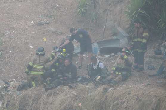 Un grupo de bomberos es atendido por un vecino que bajó a repartir agua pura después de su labor. Foto Prensa Libre: Óscar Rivas