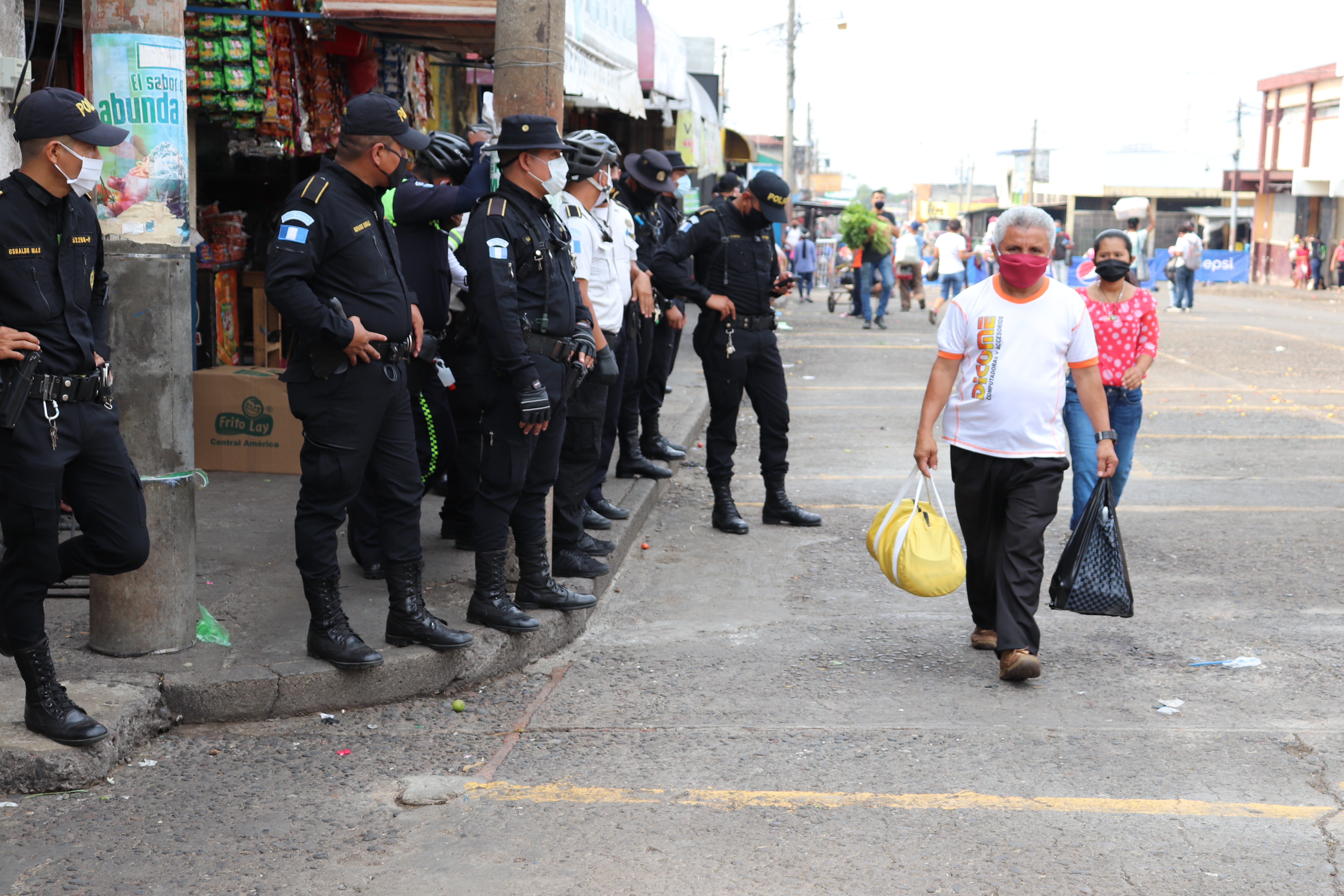 Agentes de la Policía Nacional Civil resguardan el área donde poco antes ocurrió una trifulca entre vendedores informales y policías municipales de Mazatenango. (Foto Prensa Libre: Marvin Túnchez)