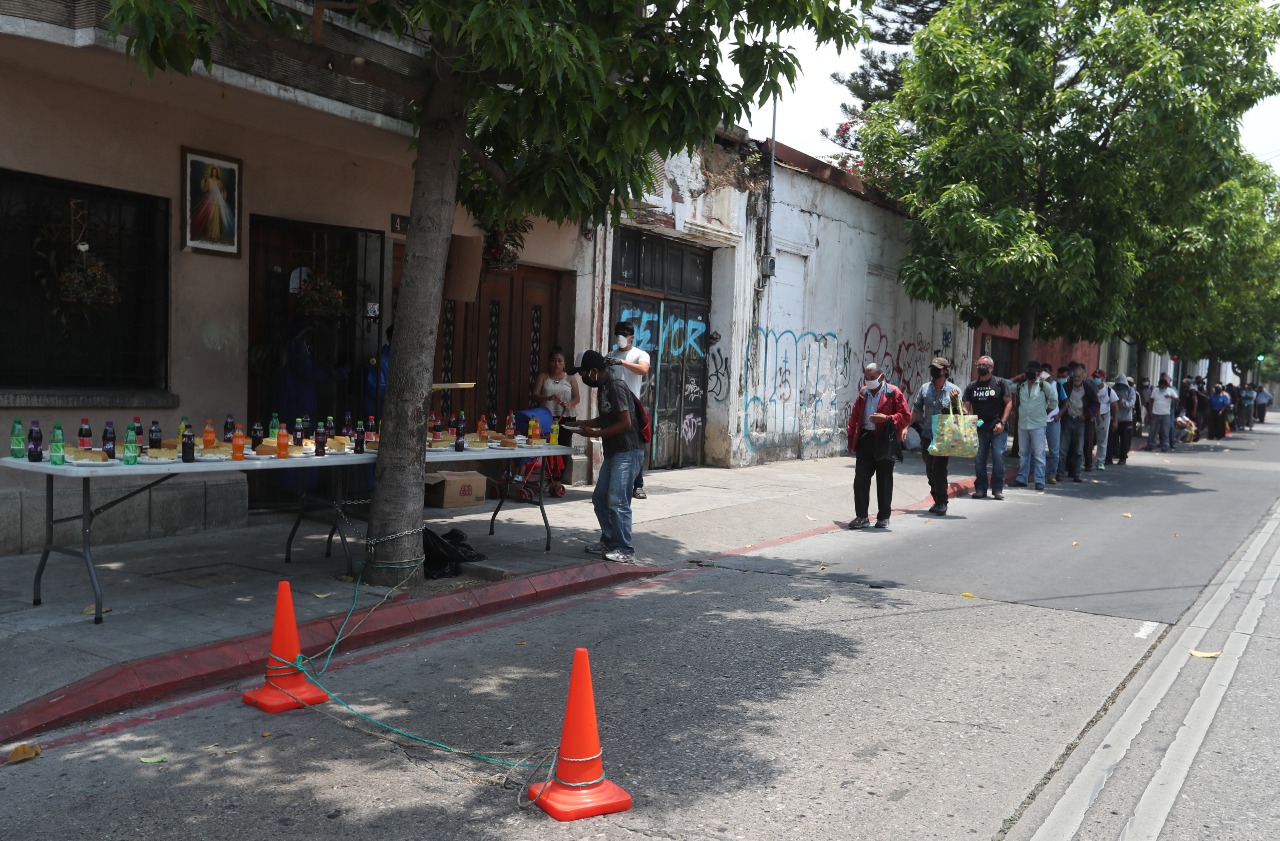 Personas afectadas por la crisis generada por el coronavirus. tienen acceso a un plato de comida que esta familia prepara. (Foto, Prensa Libre:  Óscar Rivas).