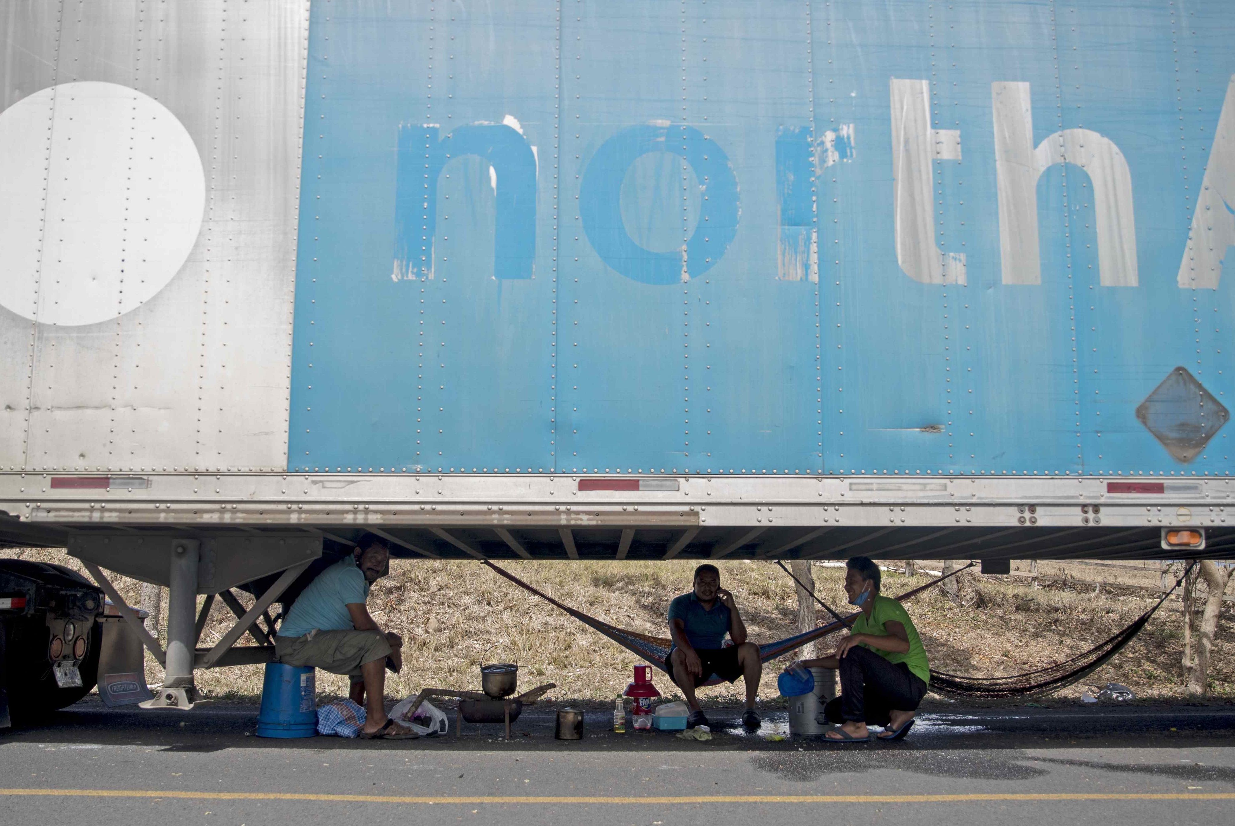 Transportistas de carga pesada, que se encuentran varados en Peñas Blancas en la frontera entre Nicaragua y Costa Rica, descansan cerca a la ciudad de Rivas (Nicaragua). (Foto Prensa Libre: EFE)