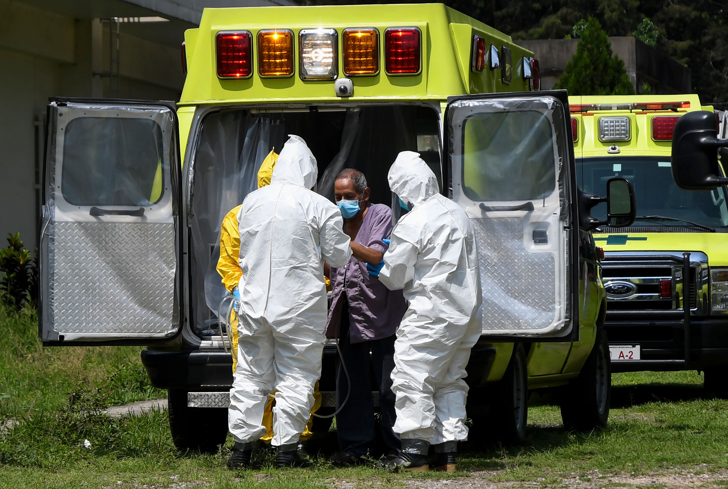 Bomberos trasladan a un paciente de coronavirus al hospital San Vicente. (Foto Prensa Libre: AFP)