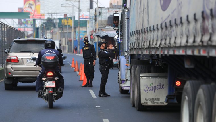 Agentes de la Policía Nacional Civil verifican documentación de constransporte de carga. (Foto Prensa Libre, Juan Diego González)