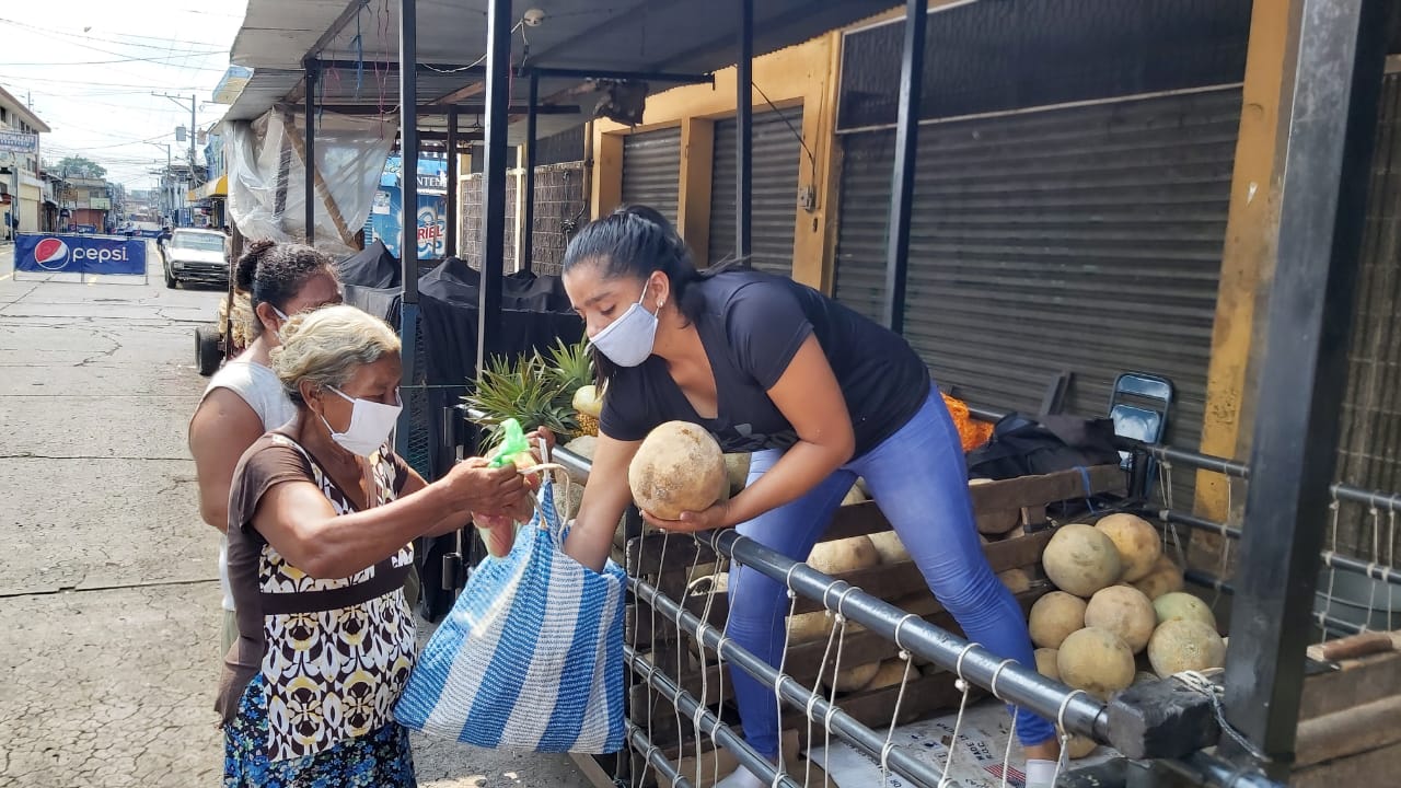 Una comerciante de frutas en el mercado de Mazatenango, Suchitepéquez. regala melones ante el cierre del mercado. (Foto Prensa Libre: Marvin Túnchez) 