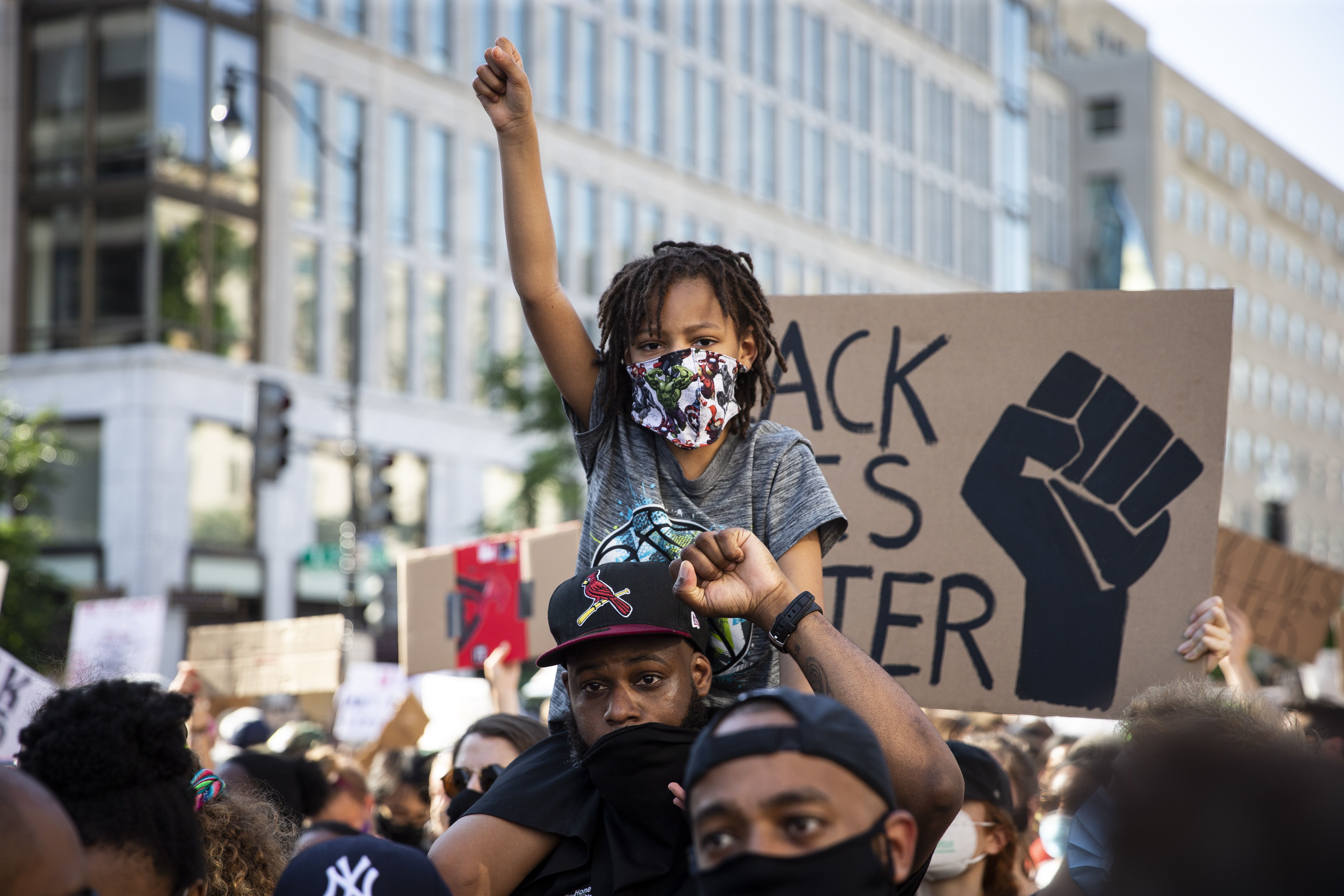 Un hombre y un niño participan en las protestas por la muerte de George Floyd cerca de la Casa Blanca. (Foto Prensa Libre: EFE)