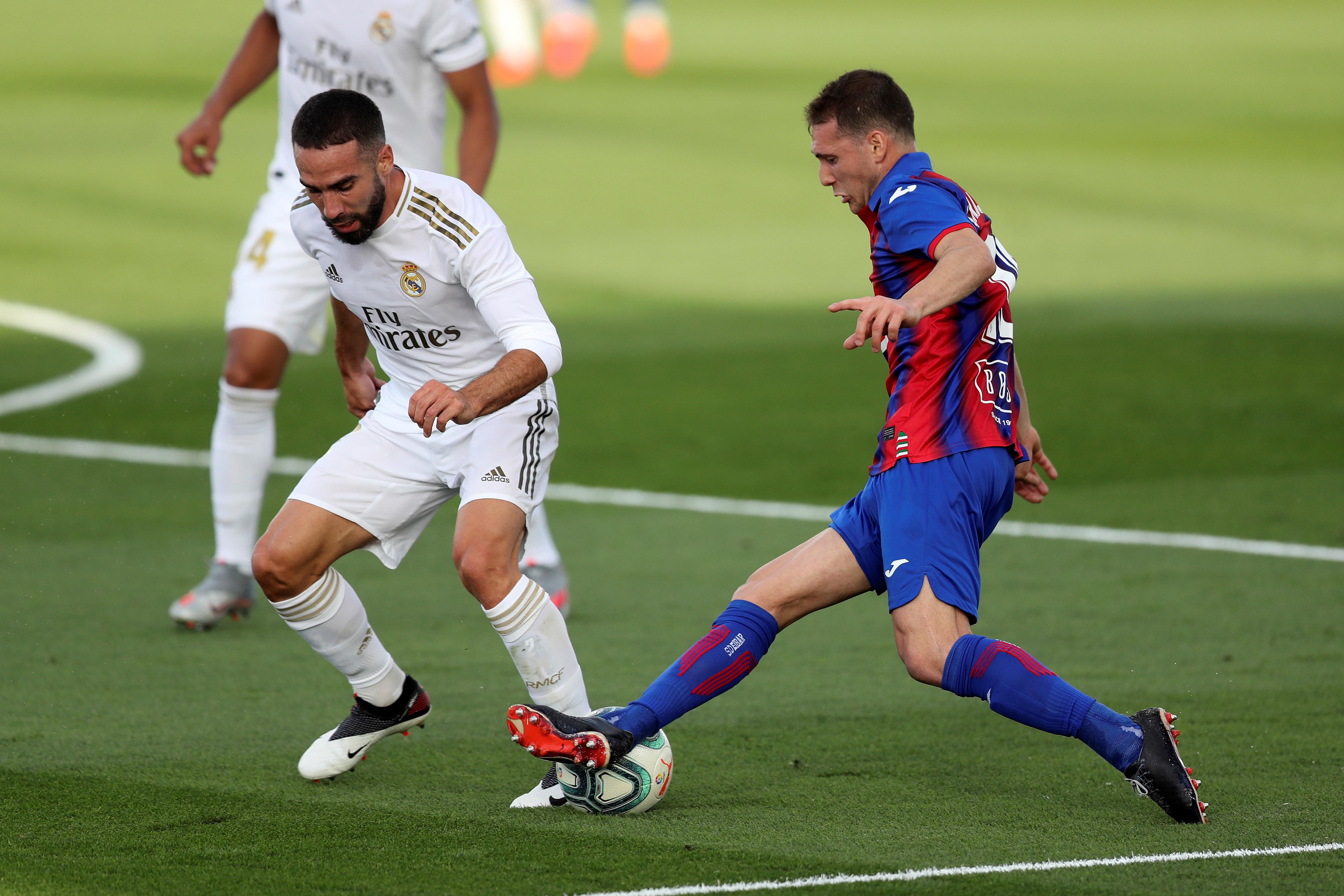 El defensa del Real Madrid Dani Carvajal, quien se resintió de un golpe (i), pelea un balón con el centrocampista uruguayo del Eibar.  (Foto Prensa Libre: EFE)