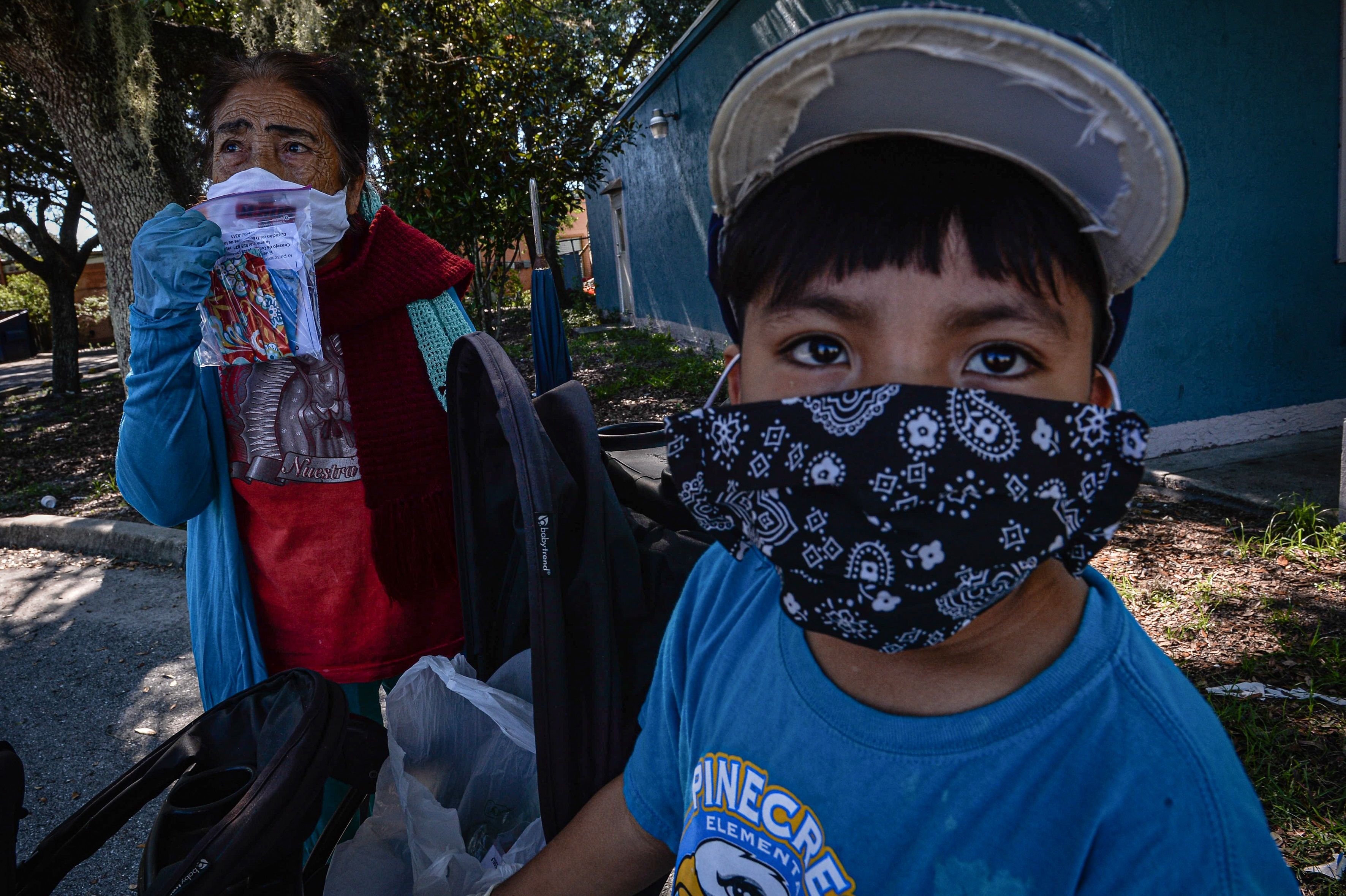 Una agricultora y su nieto visten tapabocas para protegerse del contagio covid-19 en una finca de Immokalee, Florida, donde trabajan miles de migrantes guatemaltecos. (Foto Prensa Libre: EFE)