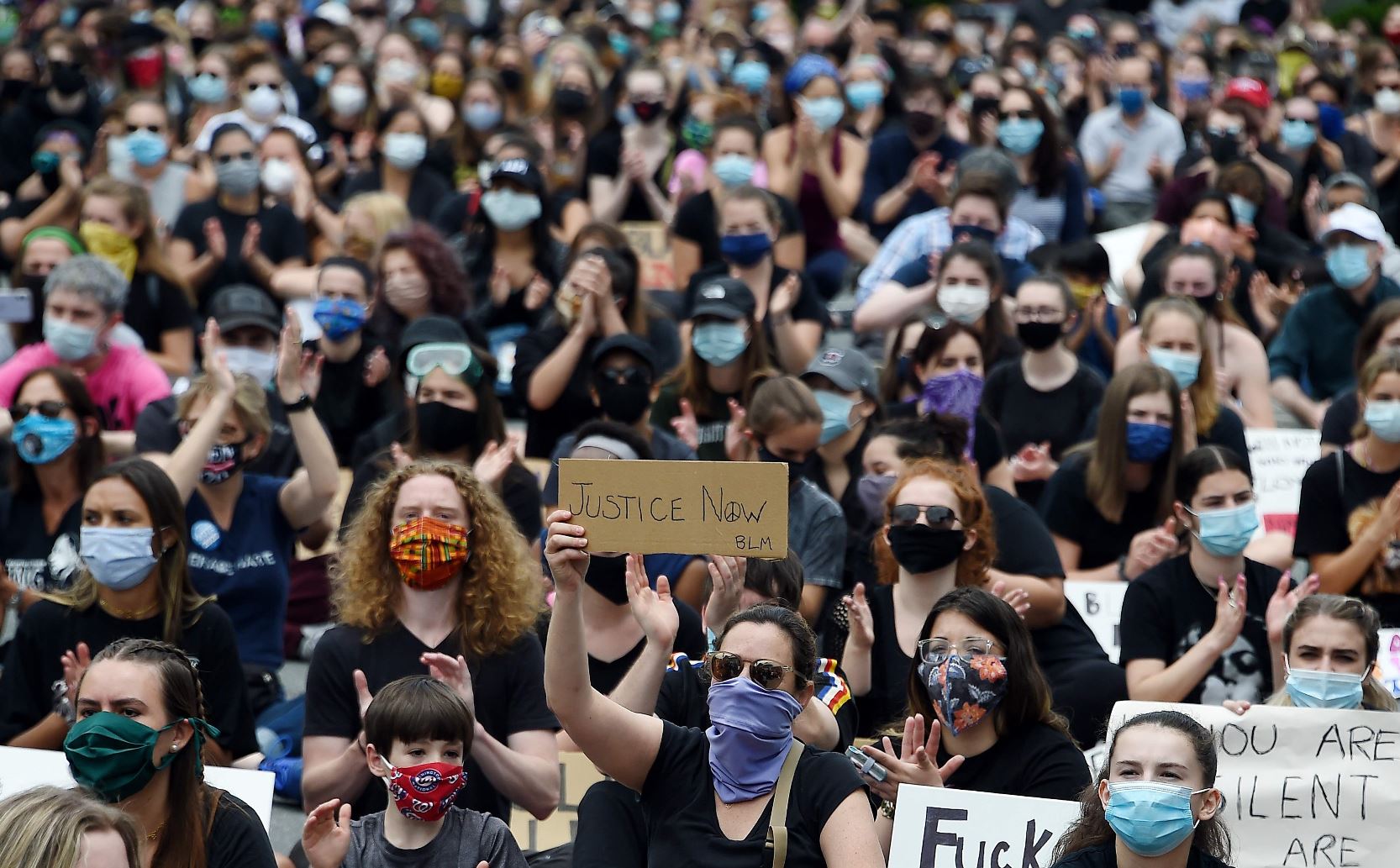 Manifestantes sostienen carteles mientras protestan en EE. UU. por la muerte de George Floyd. (Foto Prensa Libre: AFP)