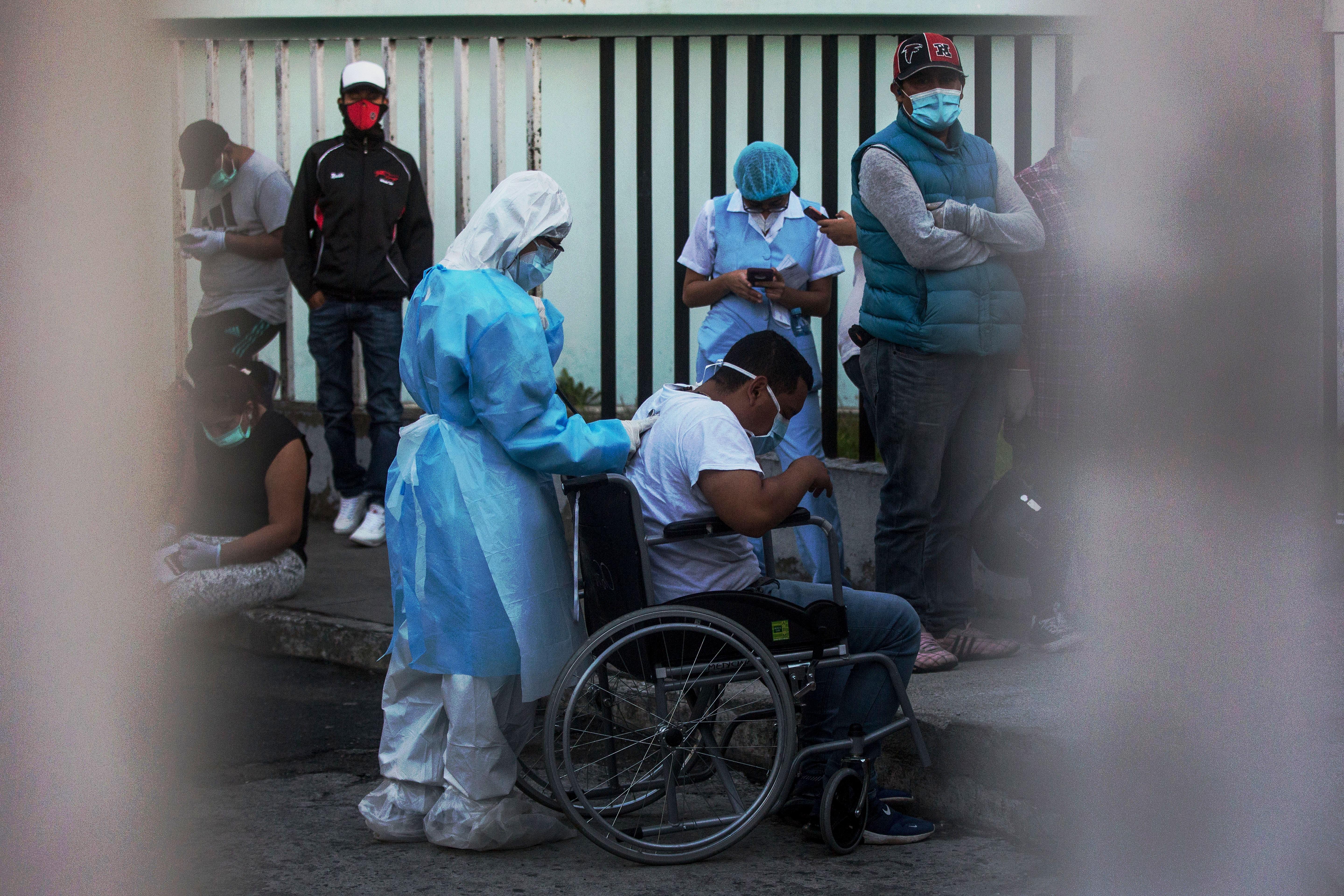 Una médico evalúa a un hombre con síntomas de coronavirus en el área de emergencias del Hospital San Juan de Dios. (Foto Prensa Libre: EFE)