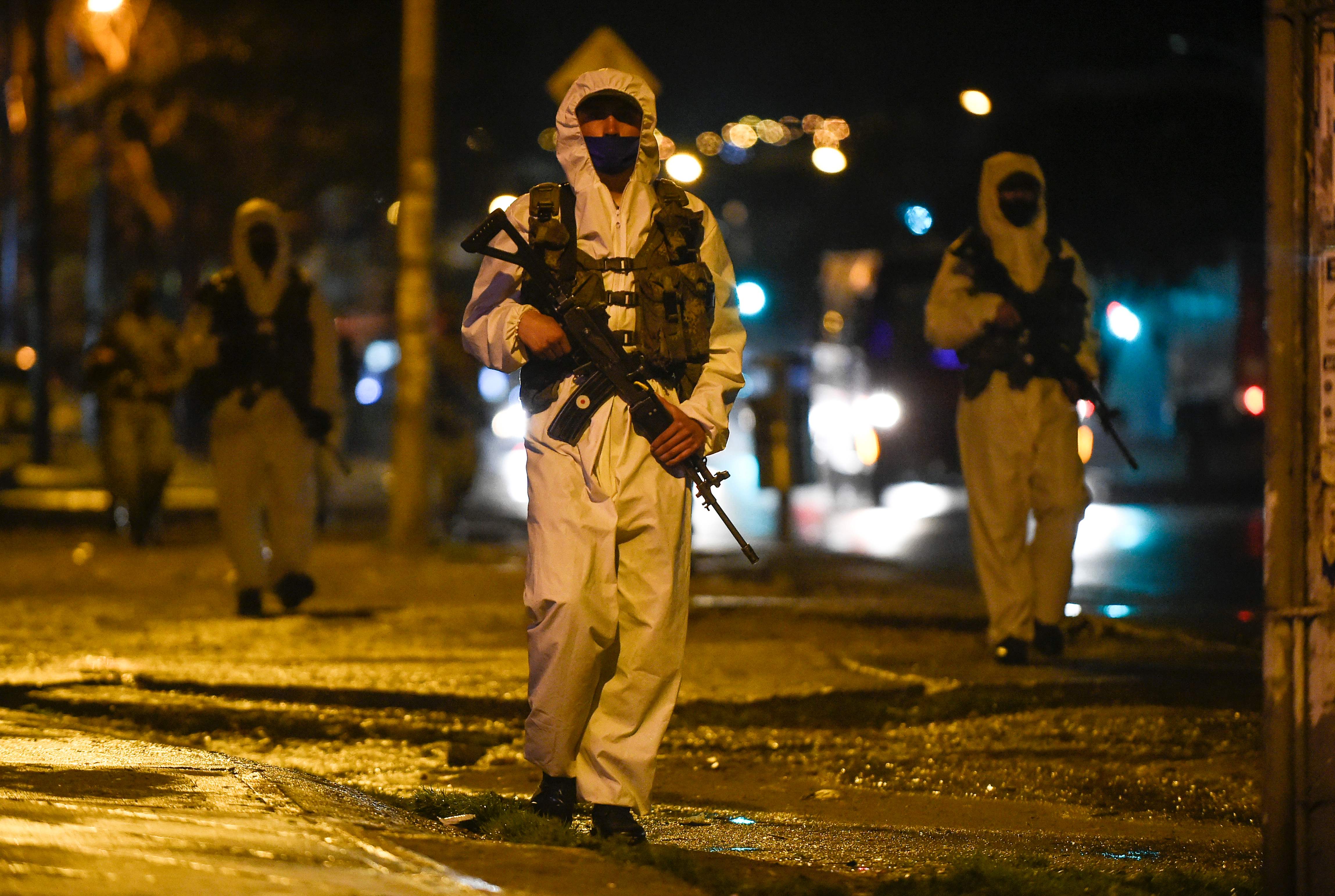 Soldados patrullan las calles de uno de los barrios de Bogotá, Colombia, donde las autoridades restringieron la movilidad de las personas para contener el avance de la pandemia de coronavirus. (Foto Prensa Libre: AFP)