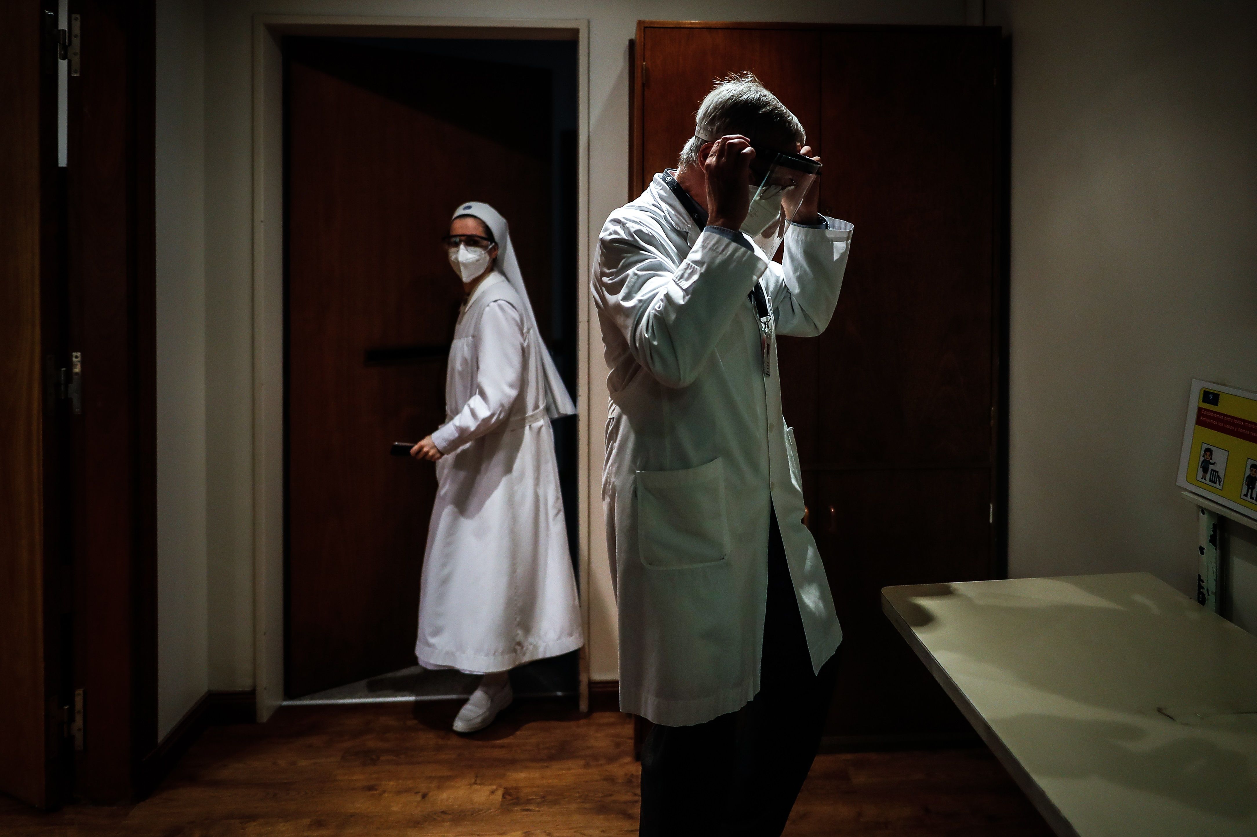 Un médico se coloca una máscara de protección en la clínica Mater Dei en la ciudad de Buenos Aires, Argentina, que permite la despedida entre familiares y pacientes terminales con coronavirus. (Foto Prensa Libre: EFE)